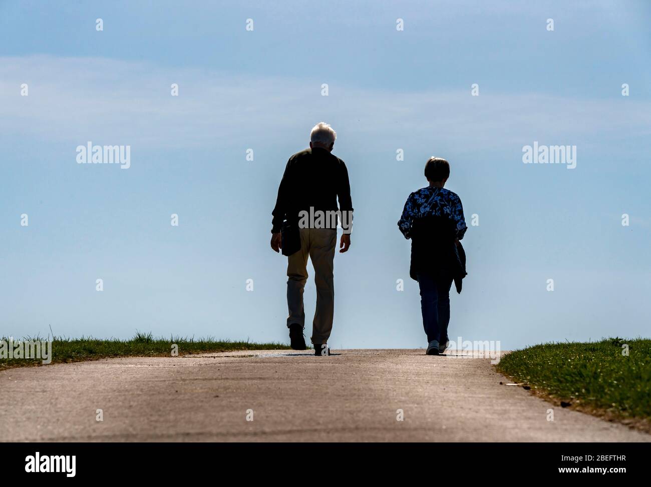 Due anziani vanno per una passeggiata su un percorso di campo, Foto Stock