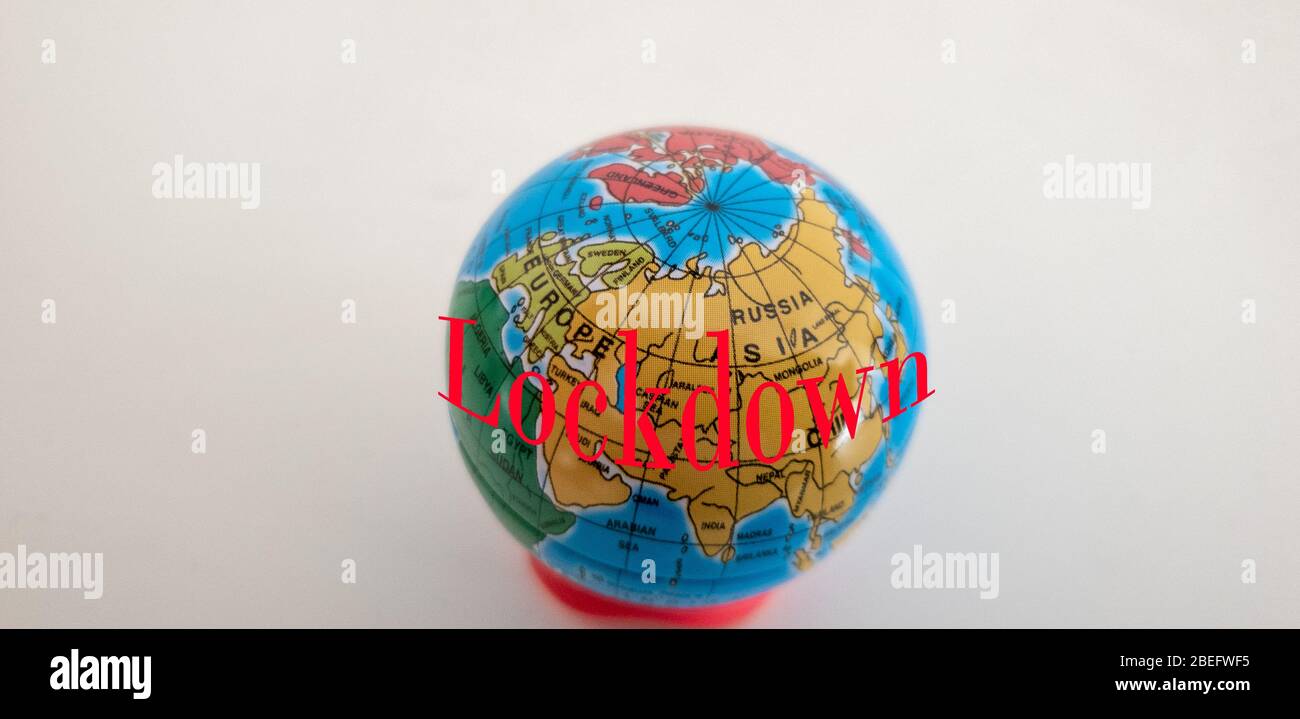 Sfera di terra in miniatura con il testo Lockdown scritto in rosso per indicare COVID-19 emergenza Svezia Foto Stock