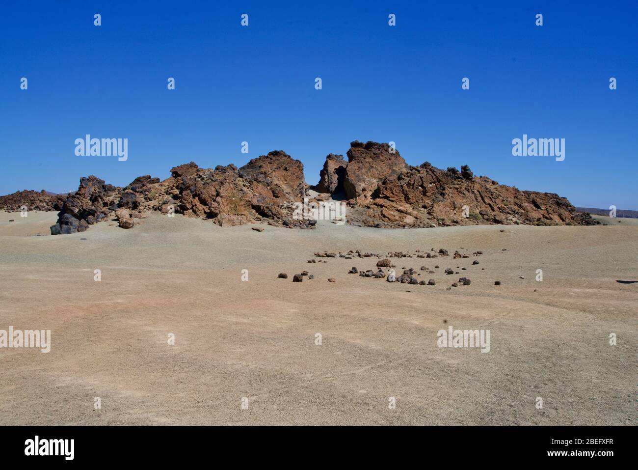 Formazione di roccia alla spiaggia sotto un cielo blu perfetto Foto Stock