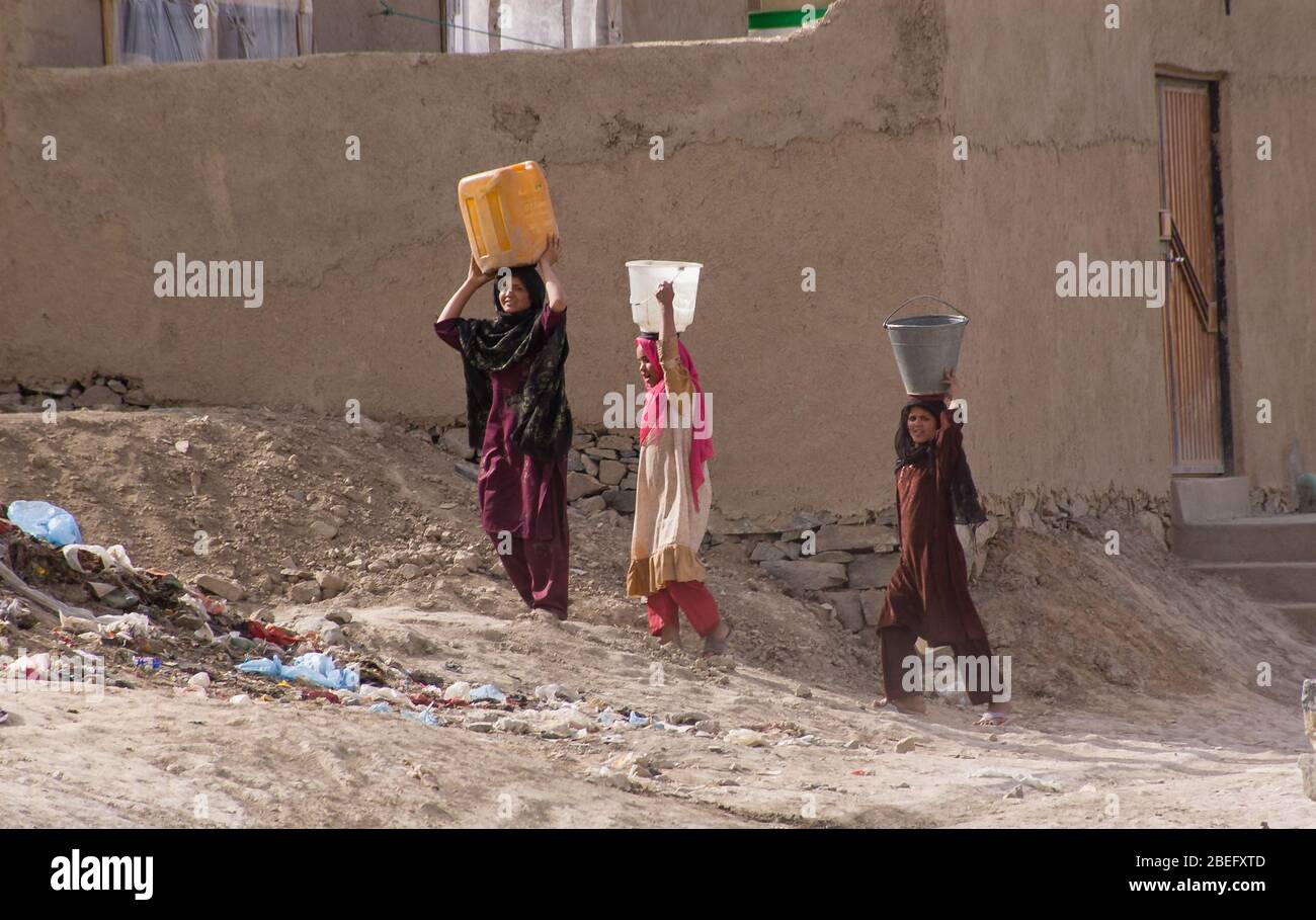 Kabul, Afghanistan - marzo 2004: Le giovani donne camminano a casa portando acqua Foto Stock