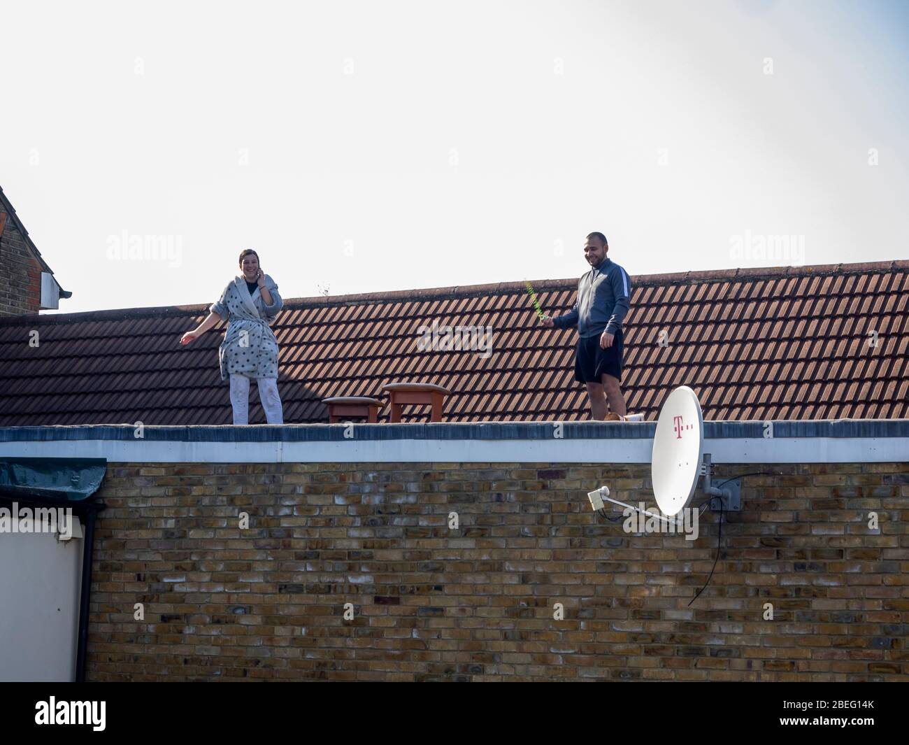 Londra. Leyton. REGNO UNITO. Il 10 aprile 2020. Vista della coppia che si è accesa il bel tempo sul tetto del loro appartamento durante il Lockdown Covid-19. Foto Stock
