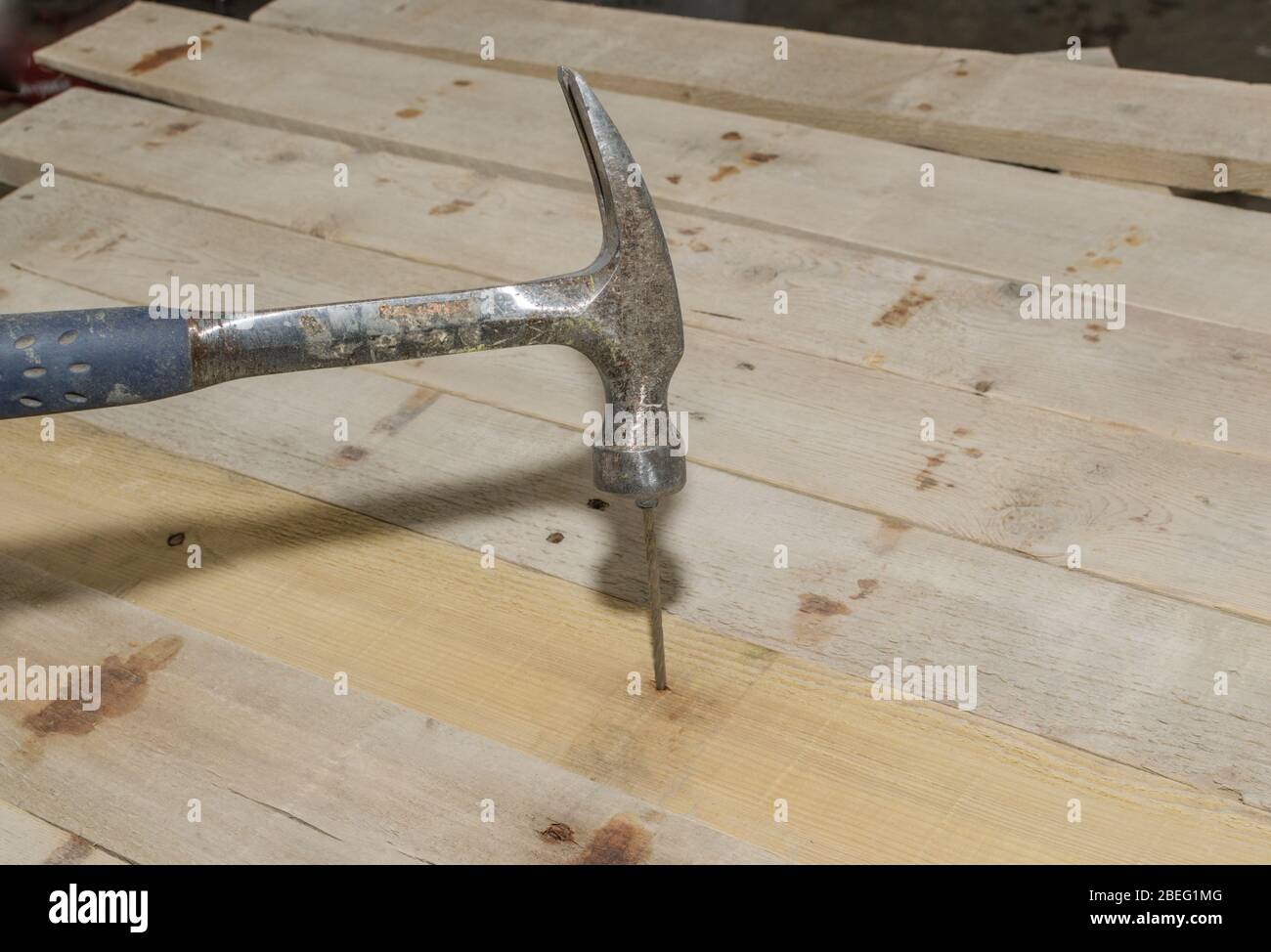 Martello e un chiodo che fissa legno di fienile rigenerato per un divertente progetto del fine settimana. Foto Stock