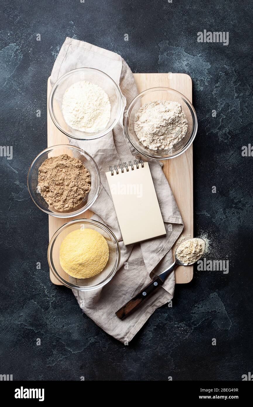 Cottura di base con ingredienti per la cottura senza glutine, mais vegetale, sesamo, avena, farina di cocco e spazio per la vostra ricetta su carta kraft Foto Stock