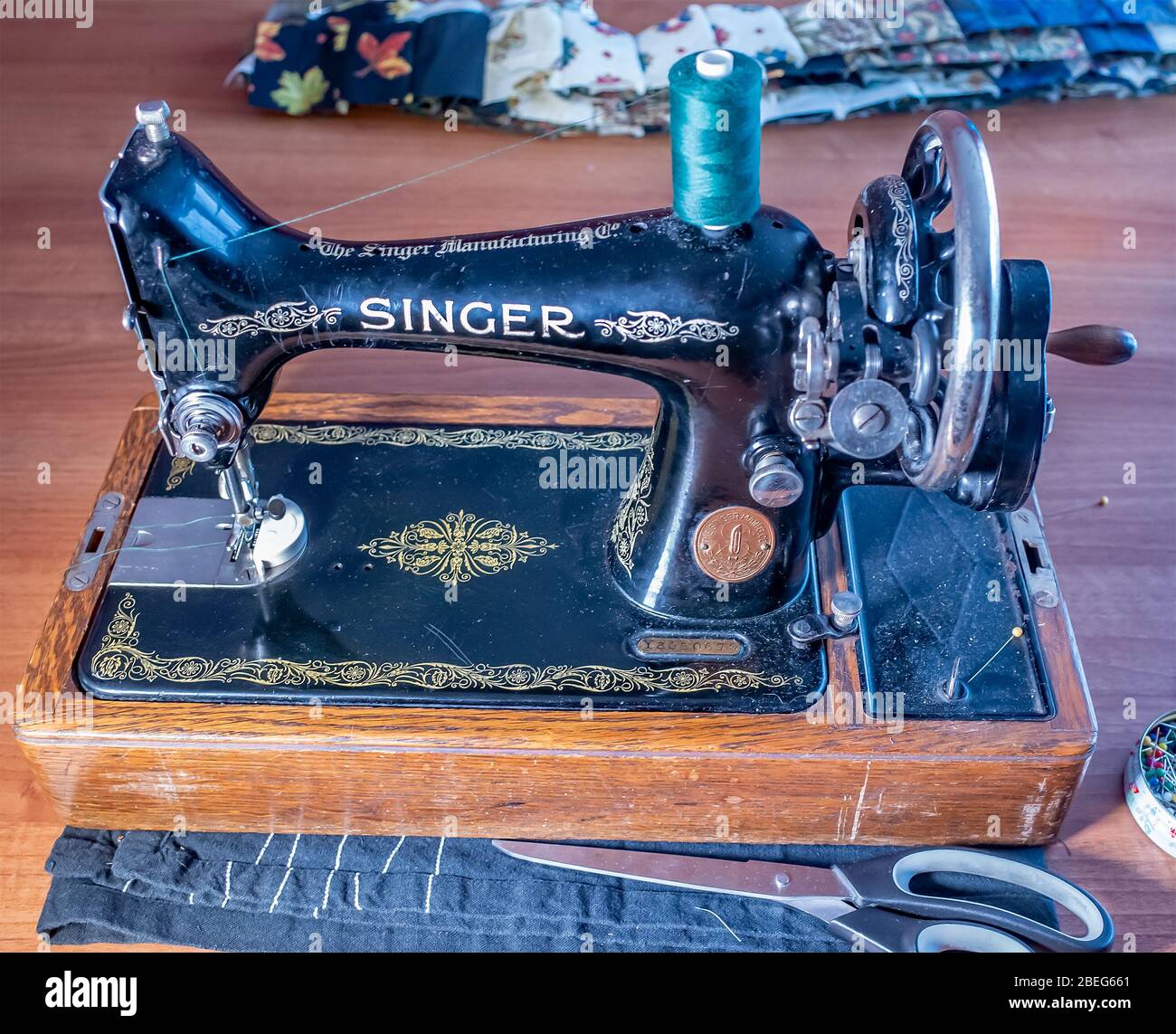 Primo piano della tradizionale macchina da cucire a mano Singer su un  tavolo di legno con relativi accessori e attrezzature per cucire Foto stock  - Alamy