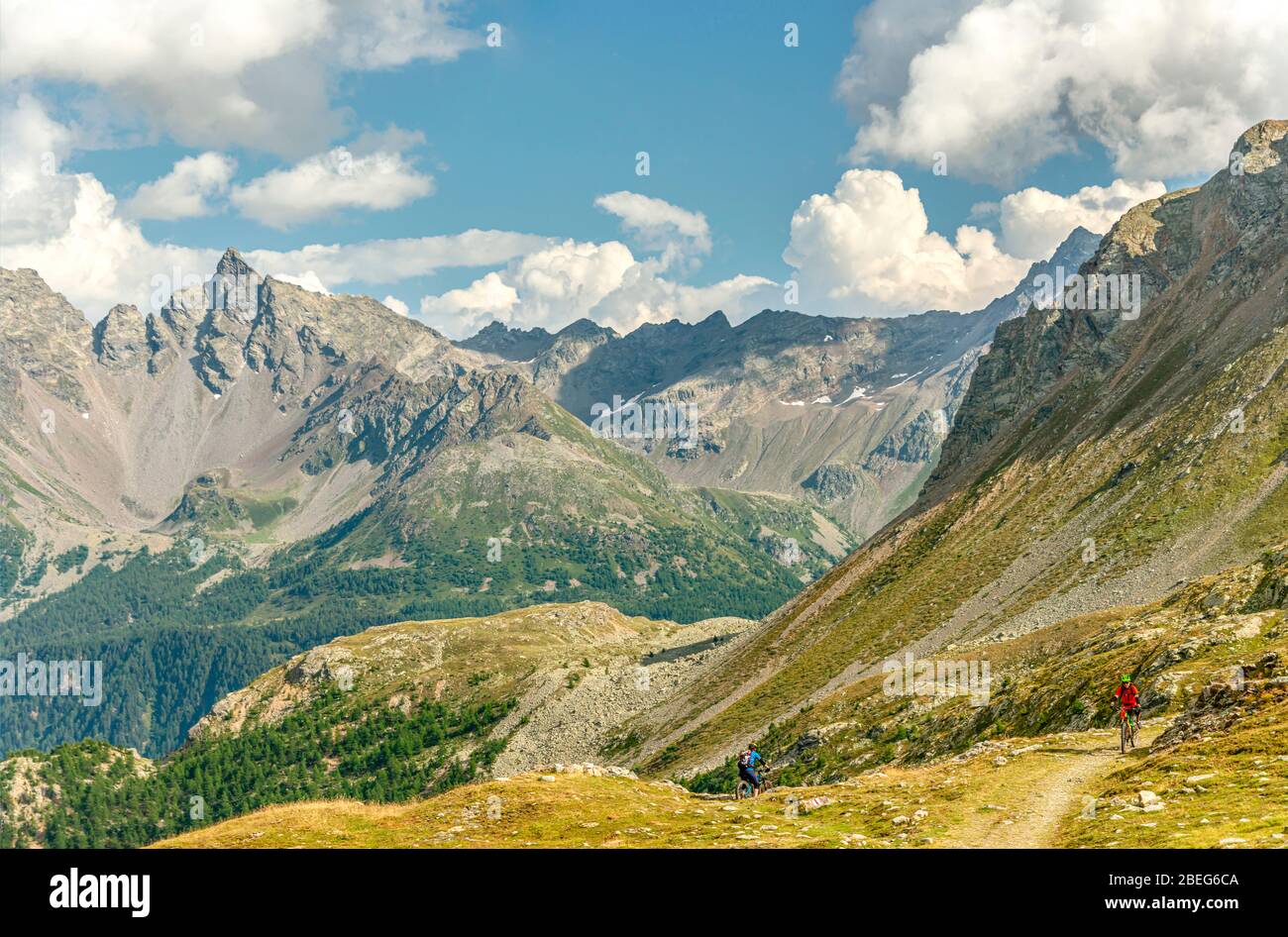 Mountainbiker in un paesaggio nella Valposchaivo visto dal Passo Bernina, Grigioni, Svizzera Foto Stock