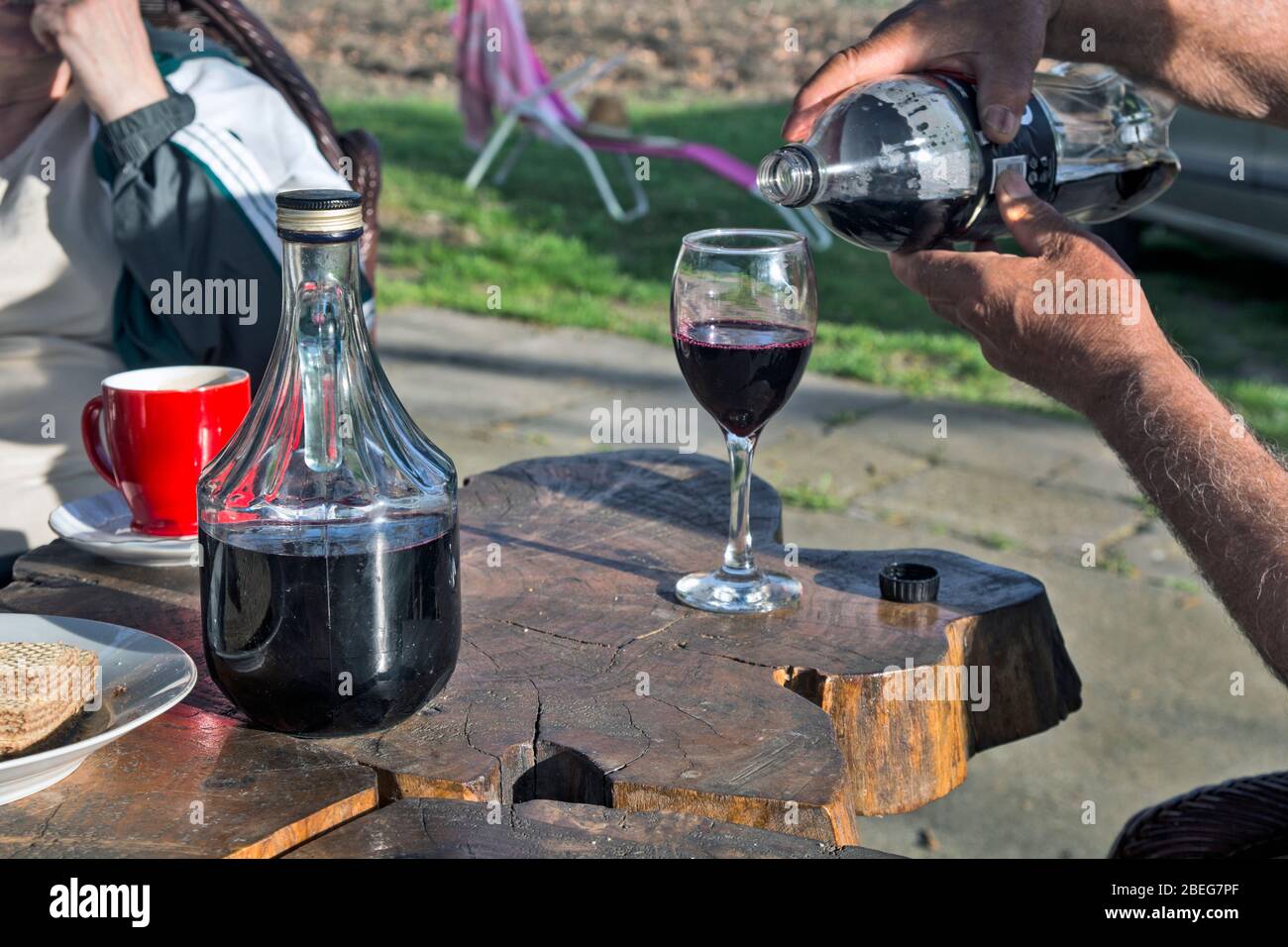 Il padrone di casa versa un ottimo vino rosso in un'atmosfera rilassata. Foto Stock