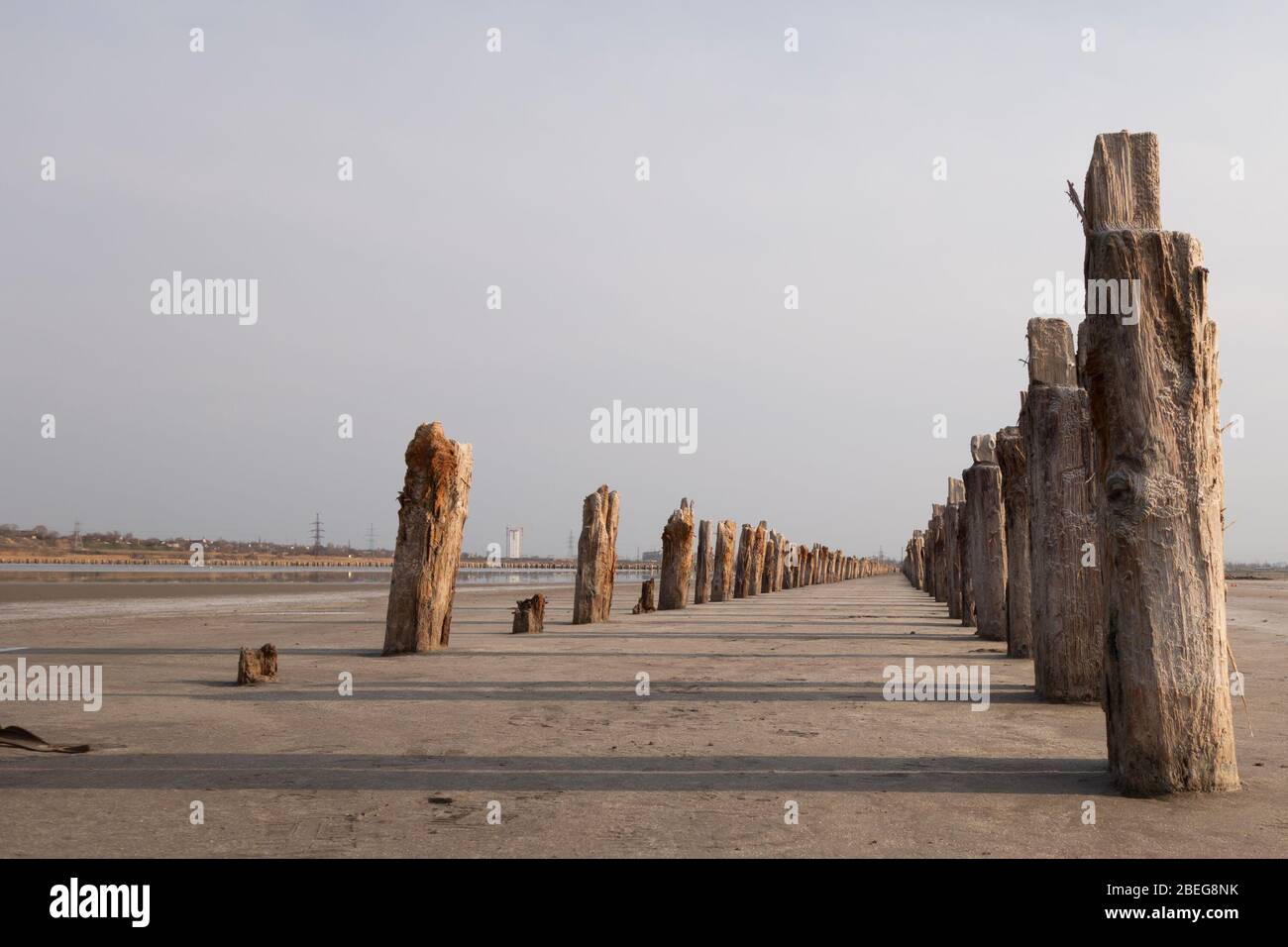 I resti di un vecchio molo. Tronchi invecchiati bastano fuori di sabbia al fondo di un serbatoio essiccato. Foto Stock