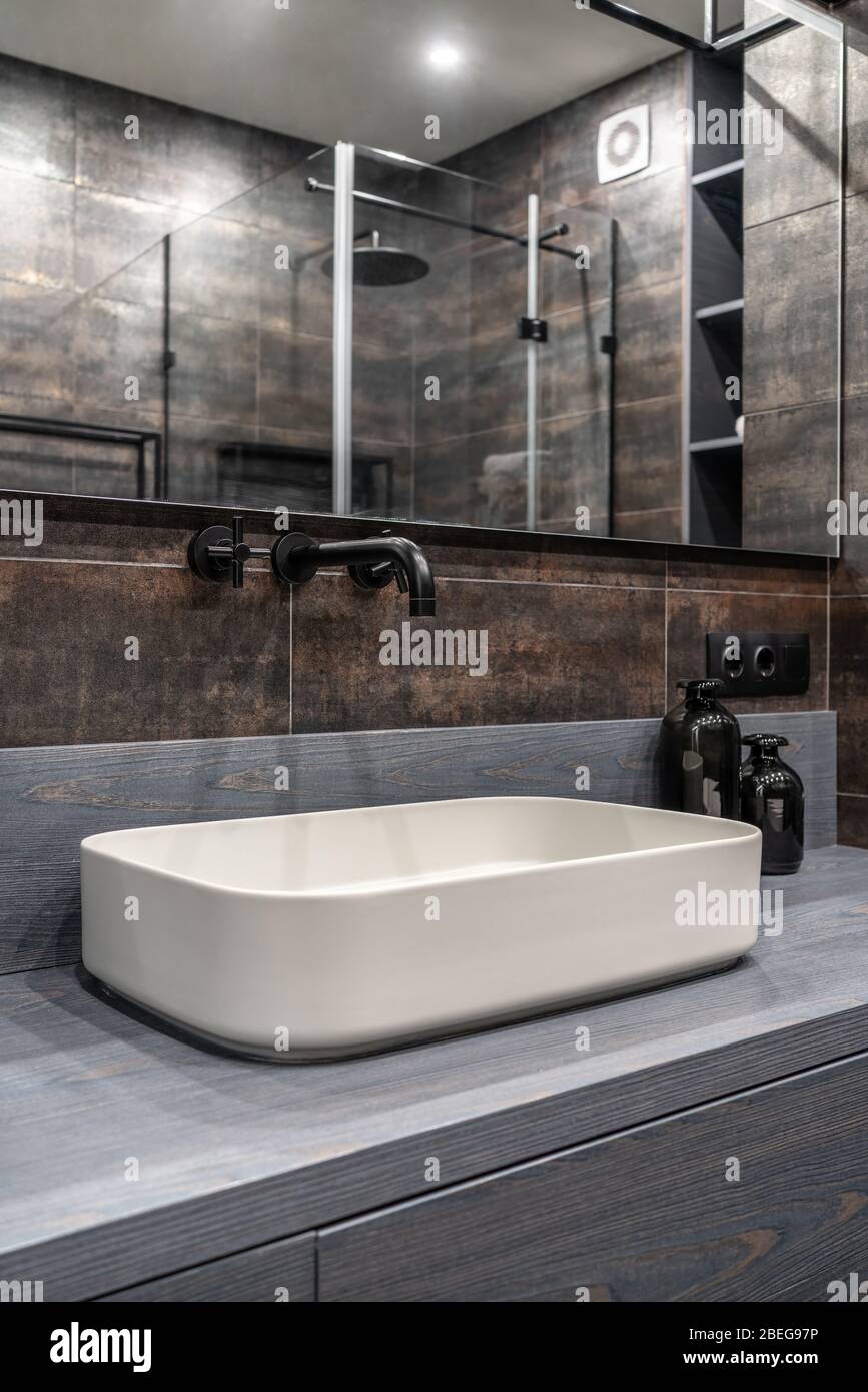 Interno di un bagno moderno e luminoso con pareti in bronzo Foto Stock