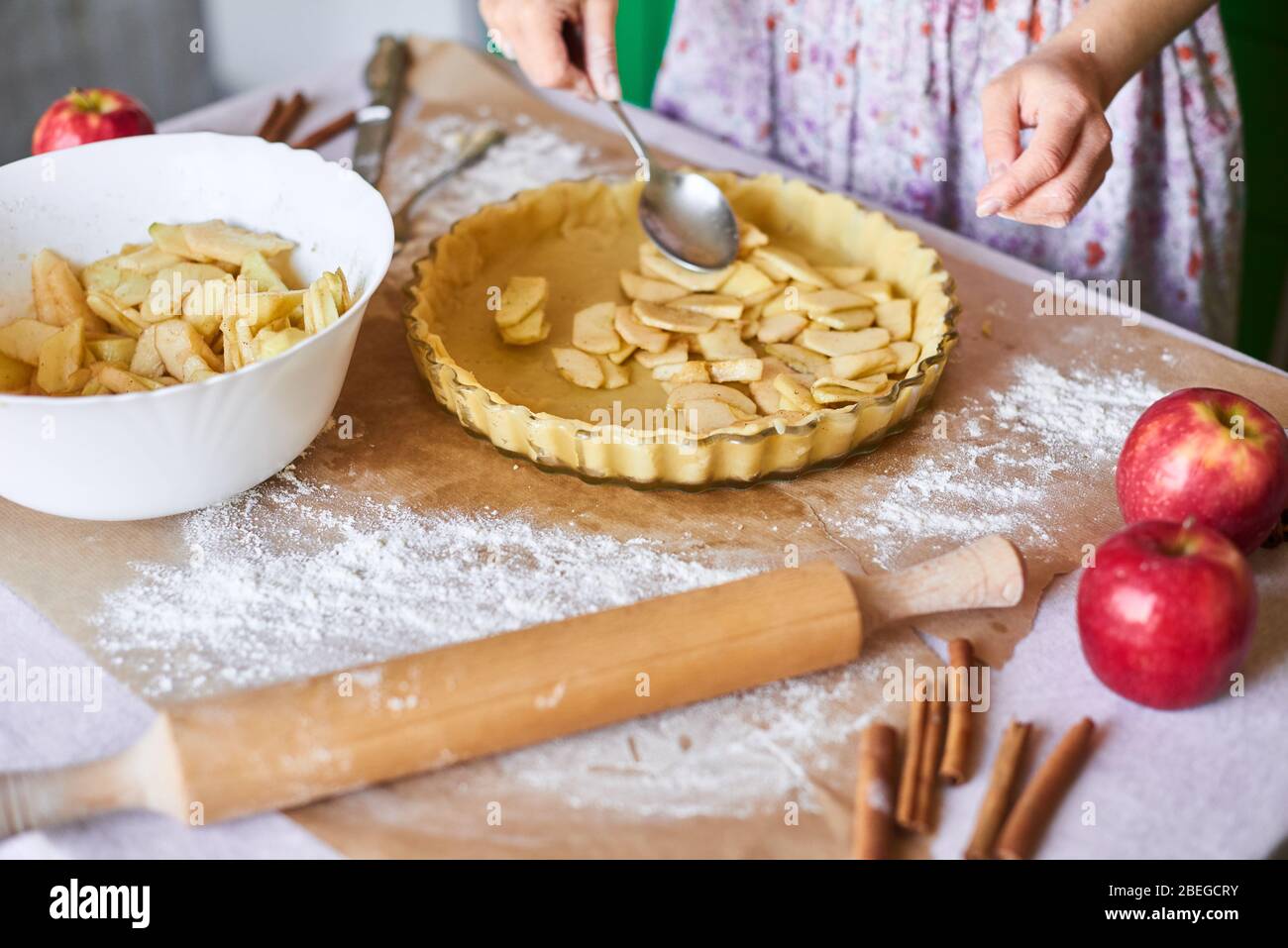 Cottura in casa delle torte dolci classiche di vacanza. Donna mani che fissano pasta sfoglia in un vassoio e ingredienti torta di zucca. Preparazione di dolci tradizionali Foto Stock