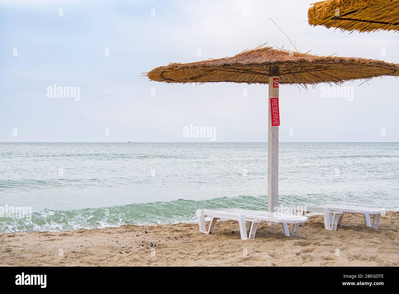 Area riservata lettini da spiaggia e un ombrellone. Foto Stock