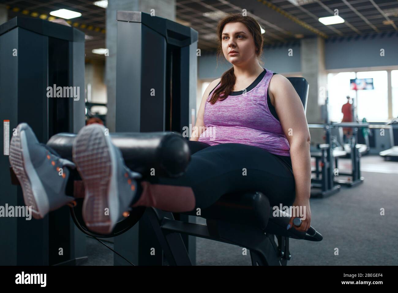 Donna in sovrappeso pompa pressa, esercizio in palestra Foto Stock