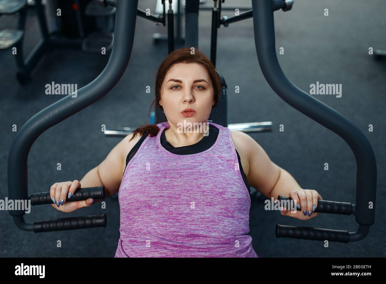 Donna in sovrappeso su macchina da ginnastica, vista dall'alto Foto Stock