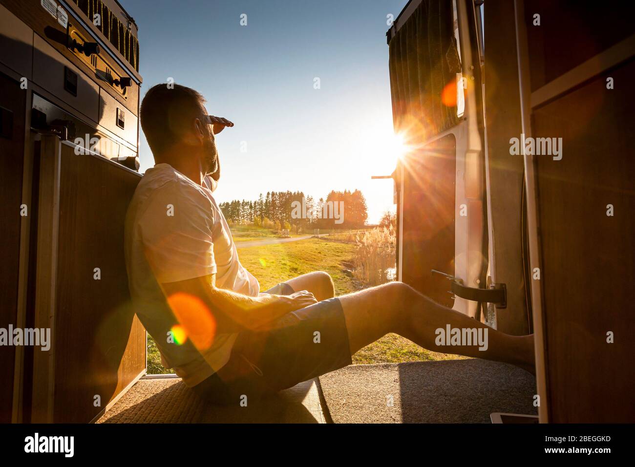 Ritratto di uomo incauta con tablet pc durante le vacanze campeggio nel suo furgone Foto Stock