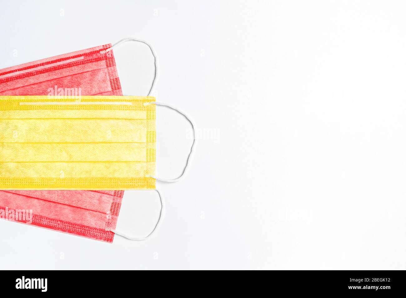 A sinistra sono 3 maschere mediche di colore giallo e rosso su sfondo chiaro. Maschere sono raccolte nella bandiera della Spagna. Medicina concetto in spagna. c Foto Stock