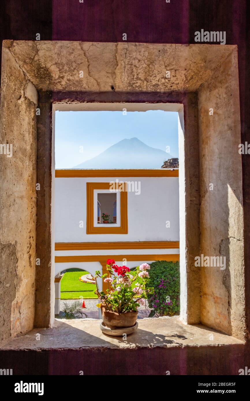 Vista distante di Volcán de Agua dalla finestra incorniciata nel convento di Iglesia y Convento de la Compañía de Jesús, Antigua, Guatemala Foto Stock