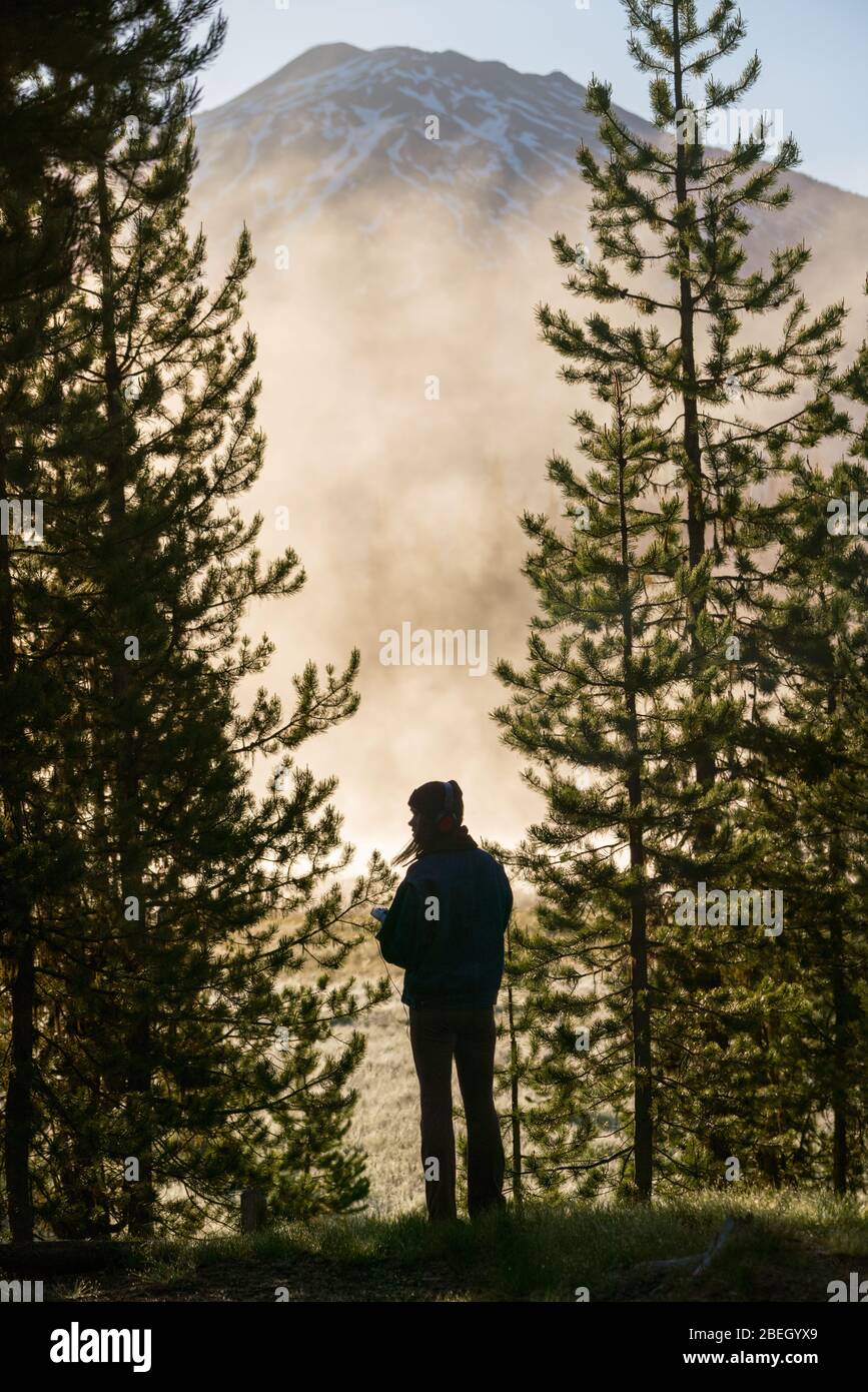 Silhouette di donna che guarda la montagna coperta di nebbia Foto Stock