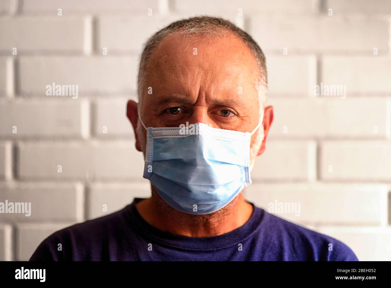 Testa di un uomo bianco che indossa una maschera sanitaria Foto Stock