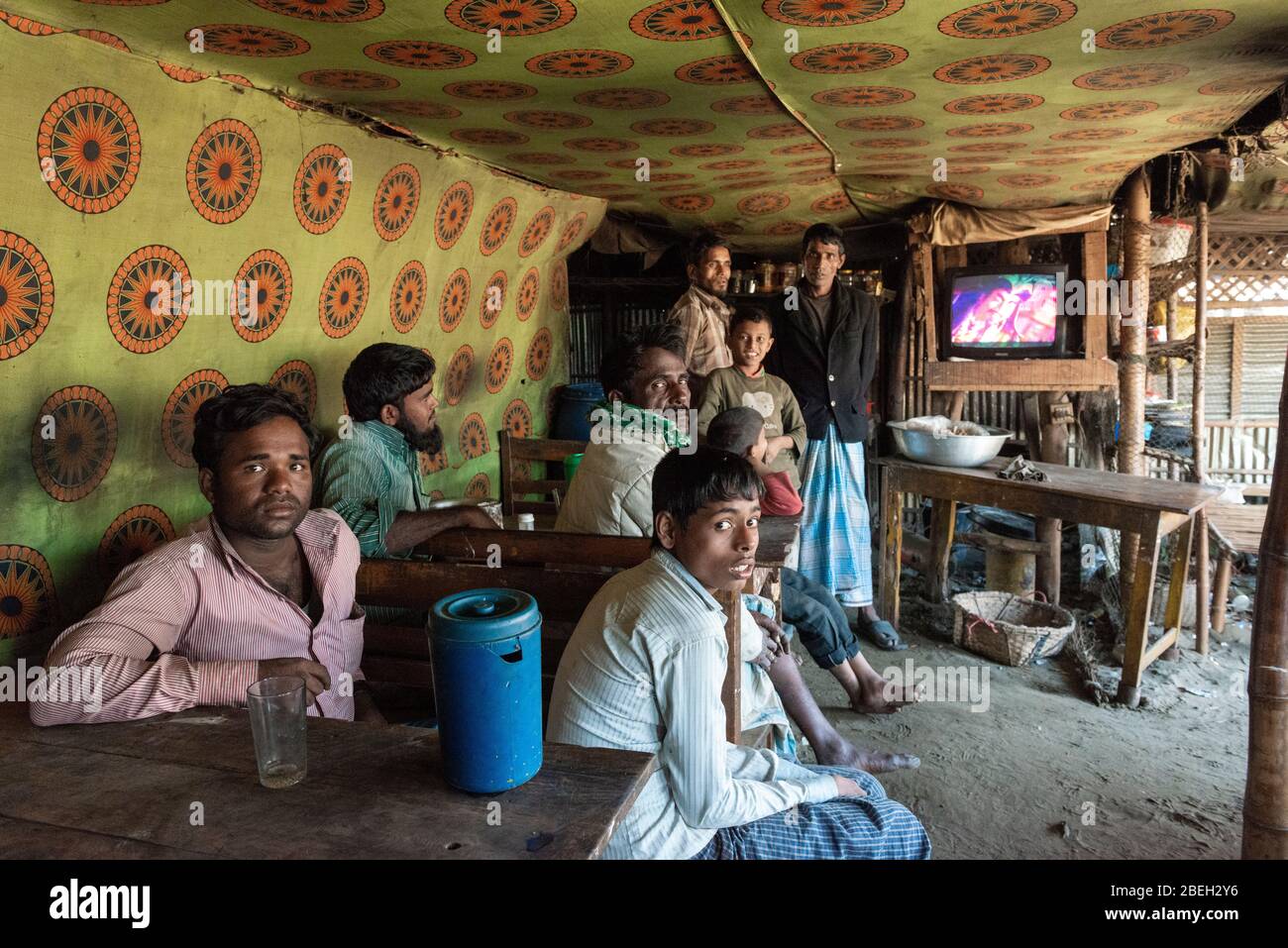 Maschi Villagers prendere un riposo e guardare la TV in un locale Café in un villaggio di pescatori a nord di Cox's Bazar Foto Stock