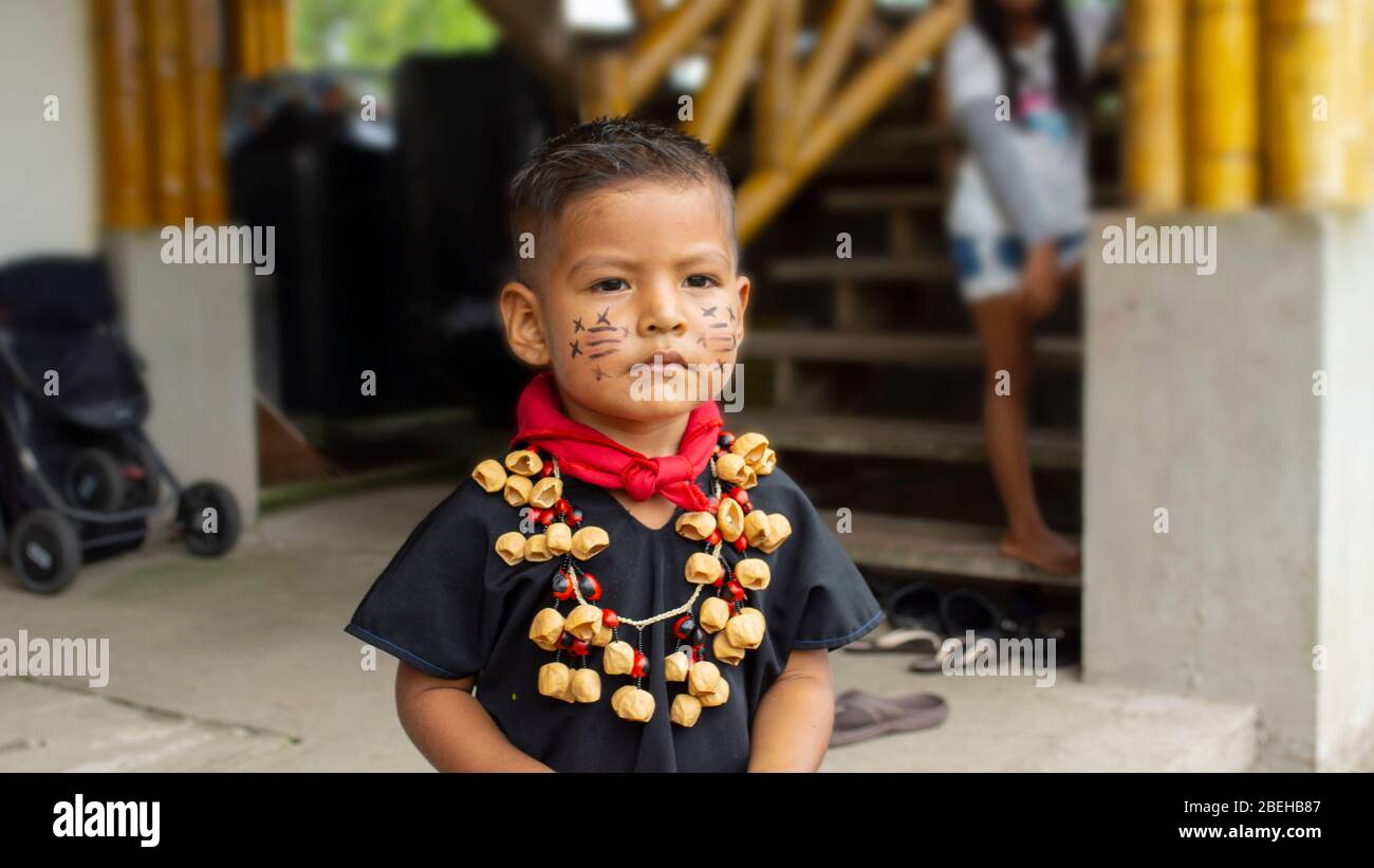 Bambino del gruppo etnico Cofan che indossa i loro abiti tradizionali adornati con una collana fatta con i semi nella comunità del millennio Cofan Dureno Foto Stock
