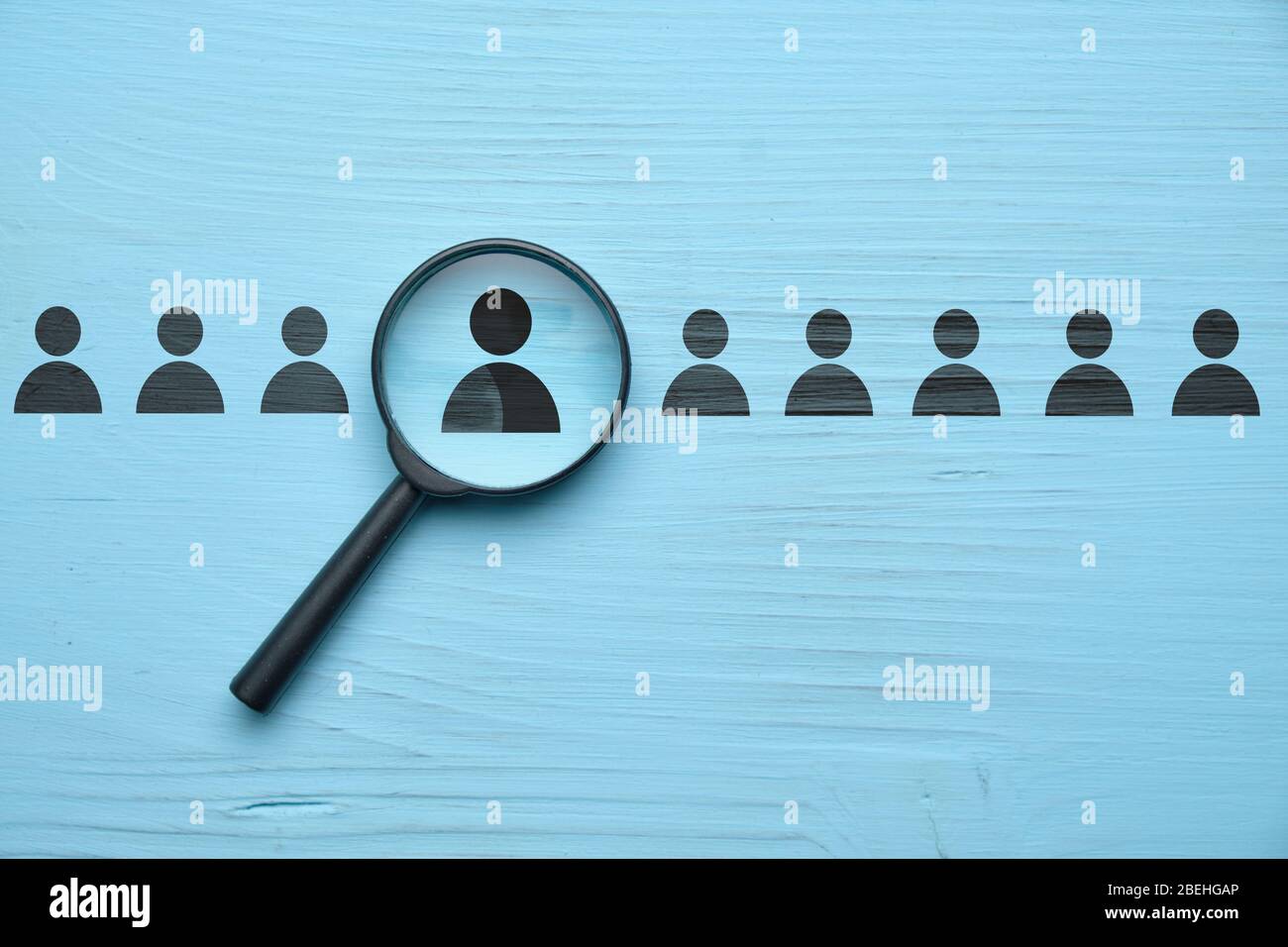 Concetto di colloquio di lavoro del dipendente - ingranditore con persona astratta su sfondo blu. Primo piano. Foto Stock