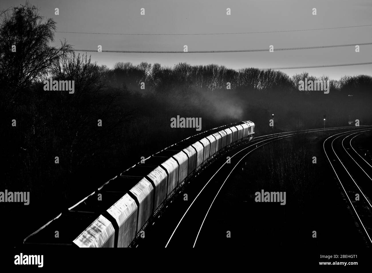 DB Cargo Rail UK Merry andare intorno al treno merci carbone in direzione del tramonto con carbone importato per una centrale elettrica Foto Stock