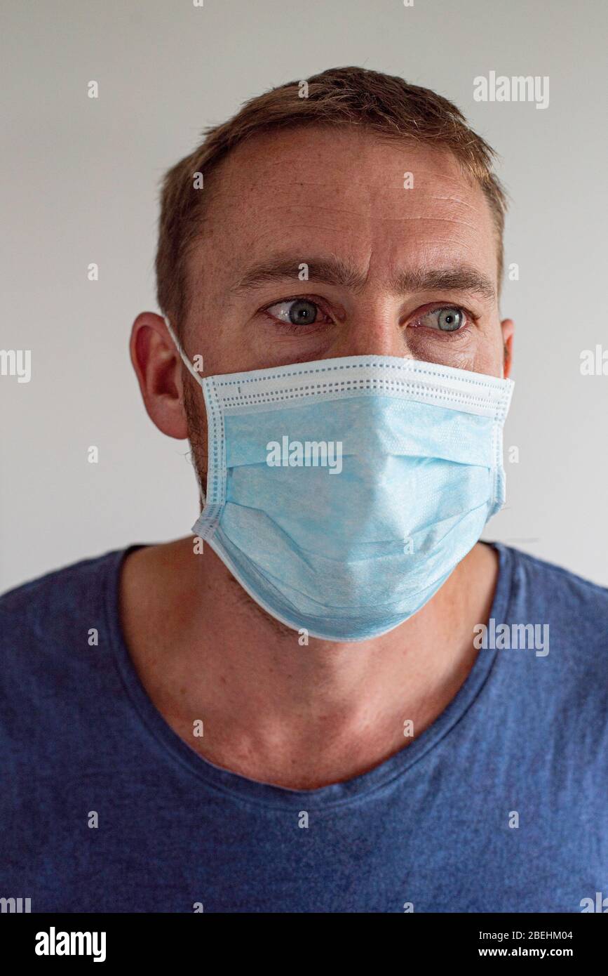 Uomo che indossa la maschera facciale durante la Pandemia Covid-19 Foto Stock