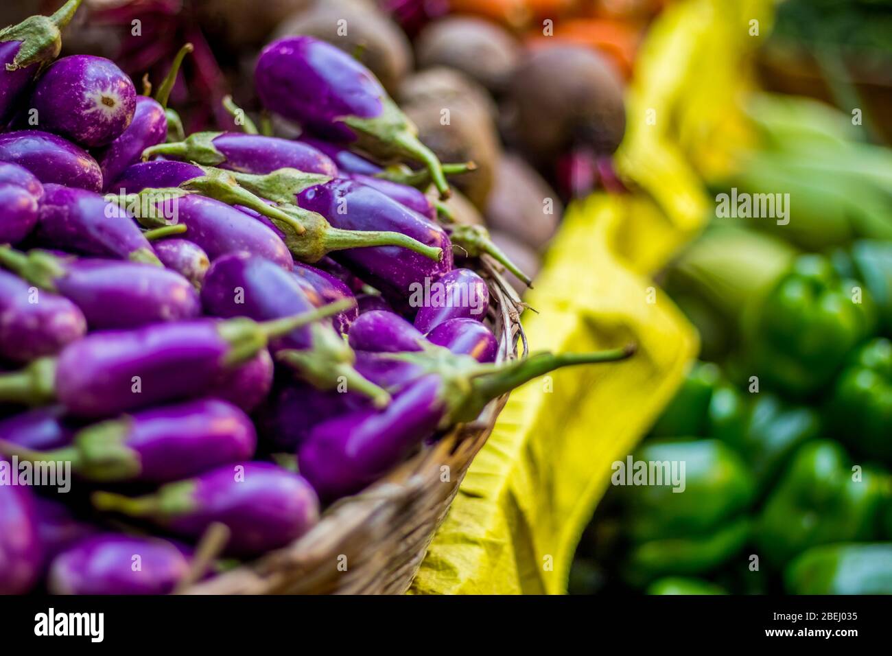 verdure sane sul mercato. Tipo di verdura in tavola. Zucca amara, barbabietola e brinja poste su un foglio giallo Foto Stock