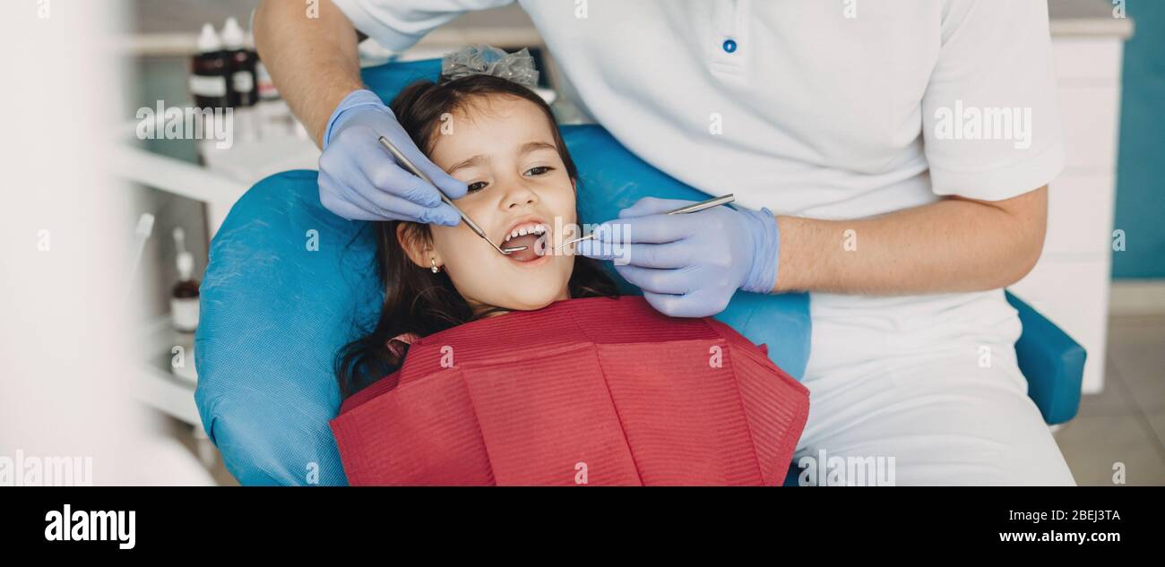 Ragazza caucasica con bocca aperta, con esame dentale presso il dentista pediatrico Foto Stock
