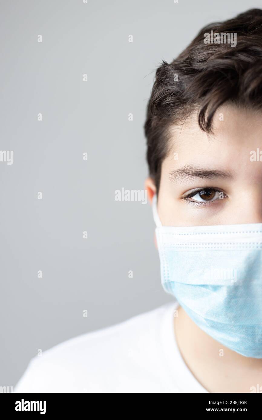 ritratto di ragazzo con maschera protettiva coronavirus guardando la macchina fotografica con copyspace Foto Stock