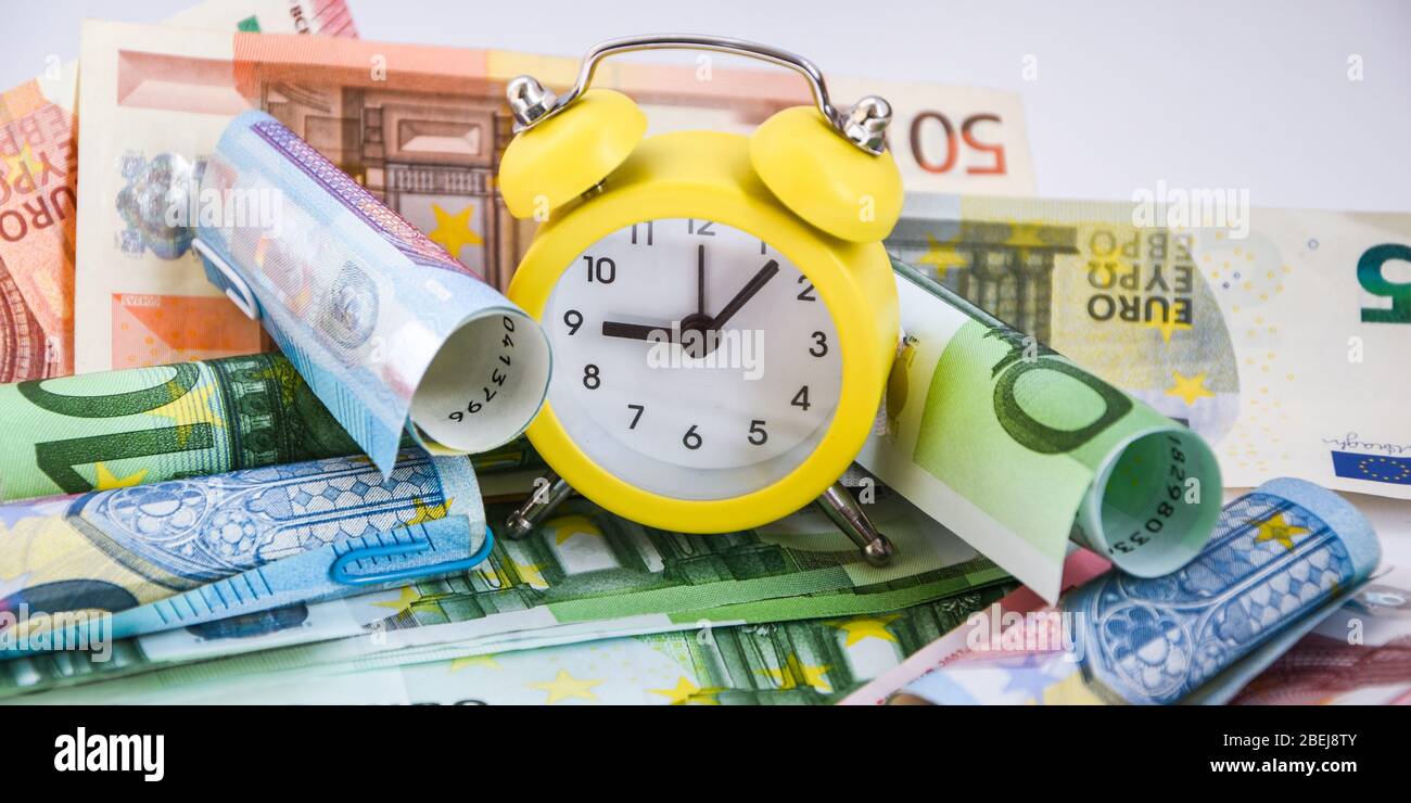 Il tempo è denaro. Stima europea del vostro tempo. Evro, sveglia, e carta europea moneta, su sfondo bianco. Concetto di business, il tempo è denaro Foto Stock