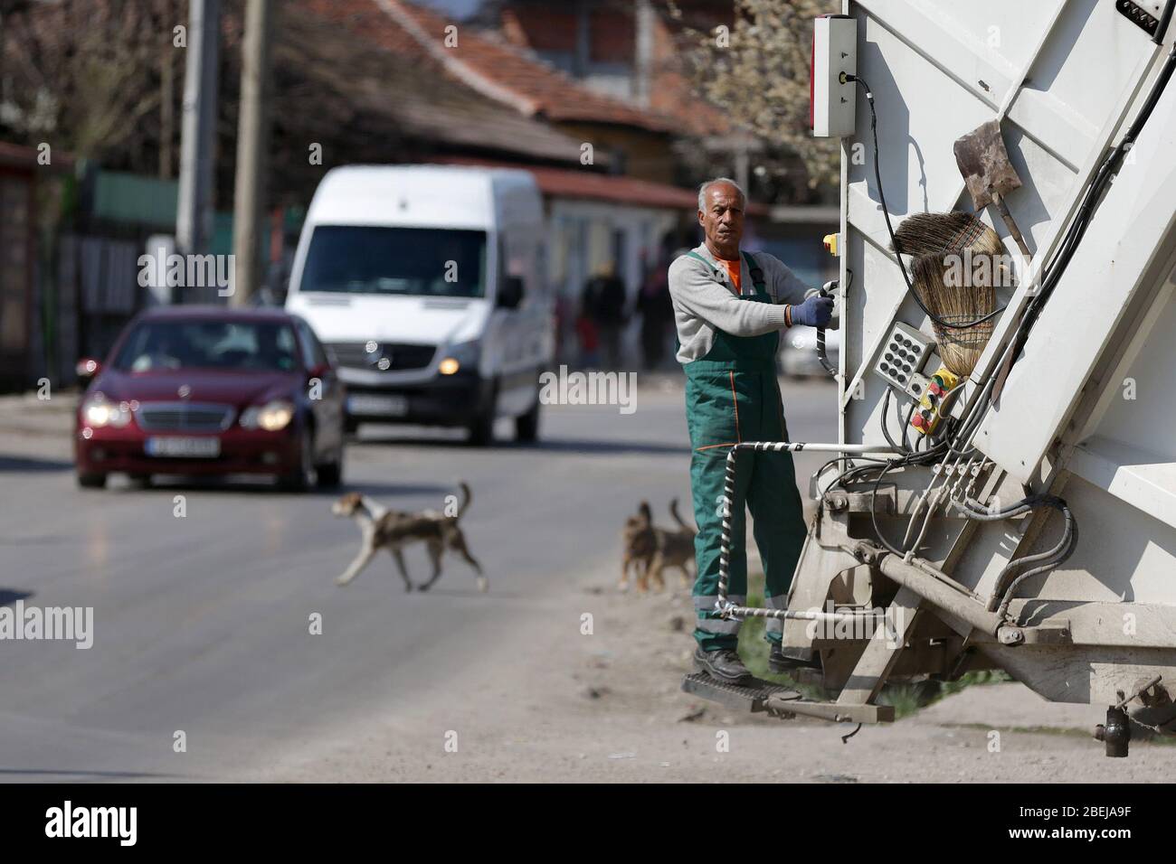 Sofia, Bulgaria - 11 aprile 2020: Il lavoratore del camion dei rifiuti viaggia sul veicolo durante il suo turno di lavoro, Foto Stock
