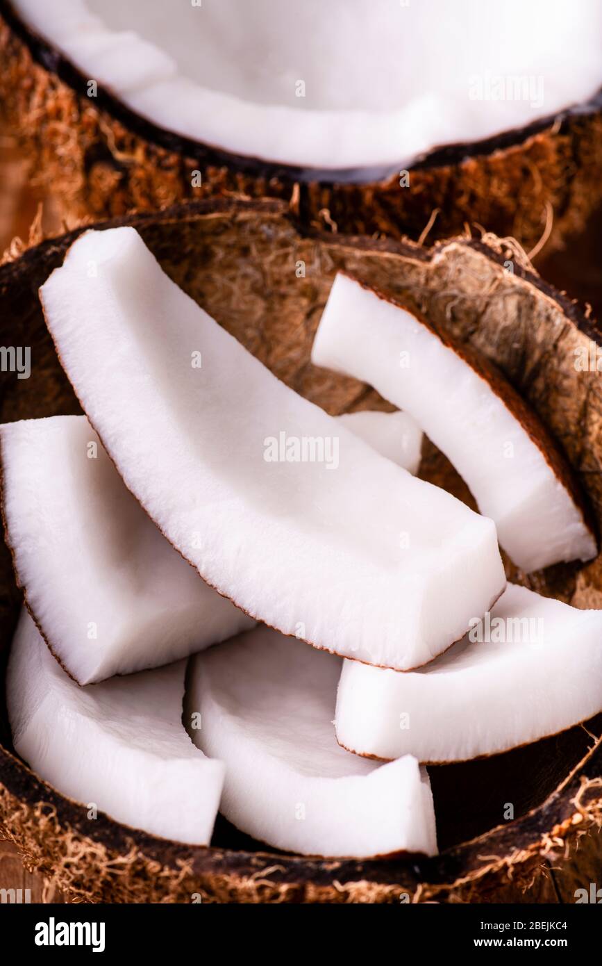 In primo piano, alcuni pezzi di cocco fresco nella conchiglia di cocco. Foto Stock