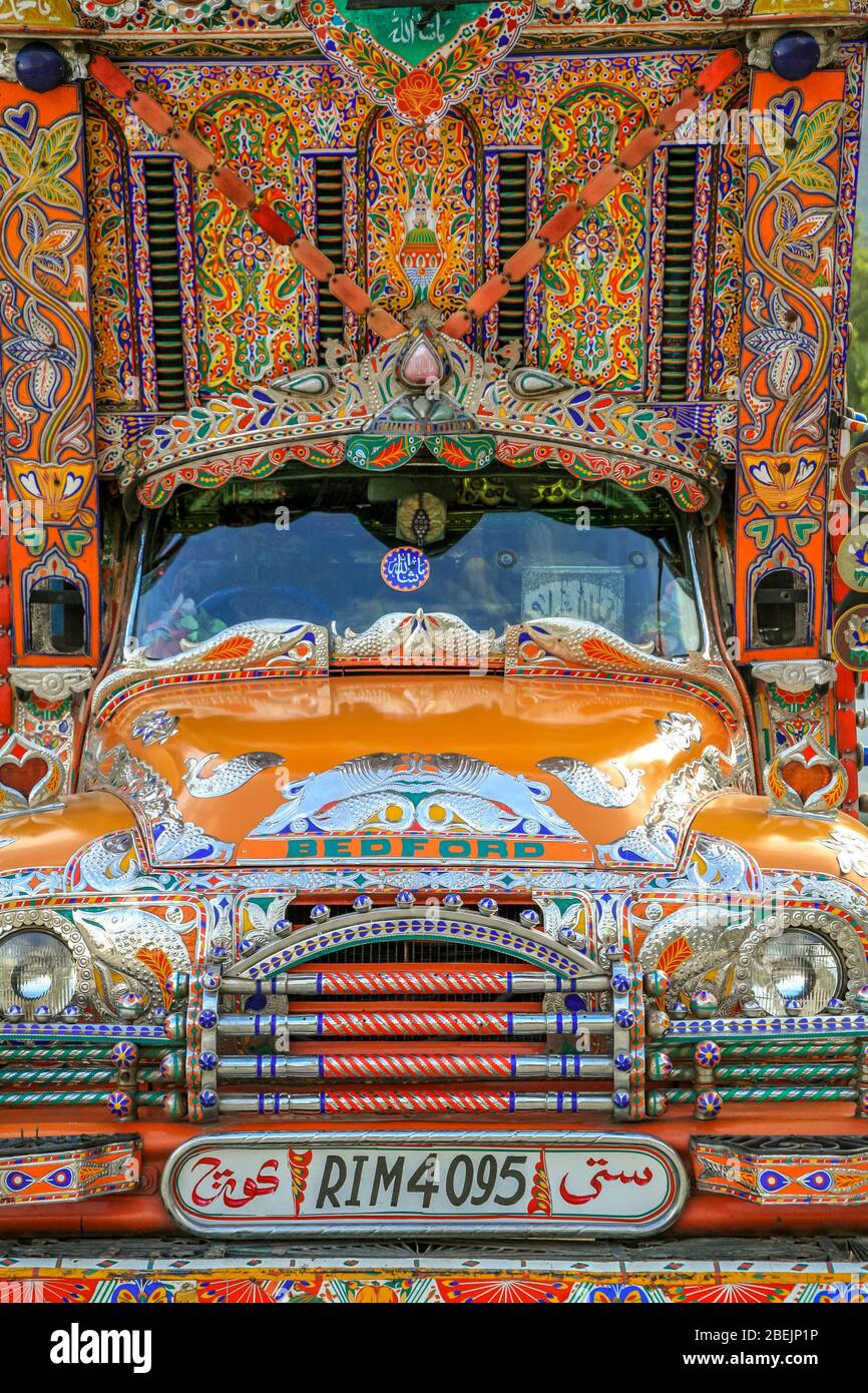 Un vecchio camion Bedford molto colorato, decorato con immagini religiose e arte tradizionale, nel Nord del Pakistan. Foto Stock
