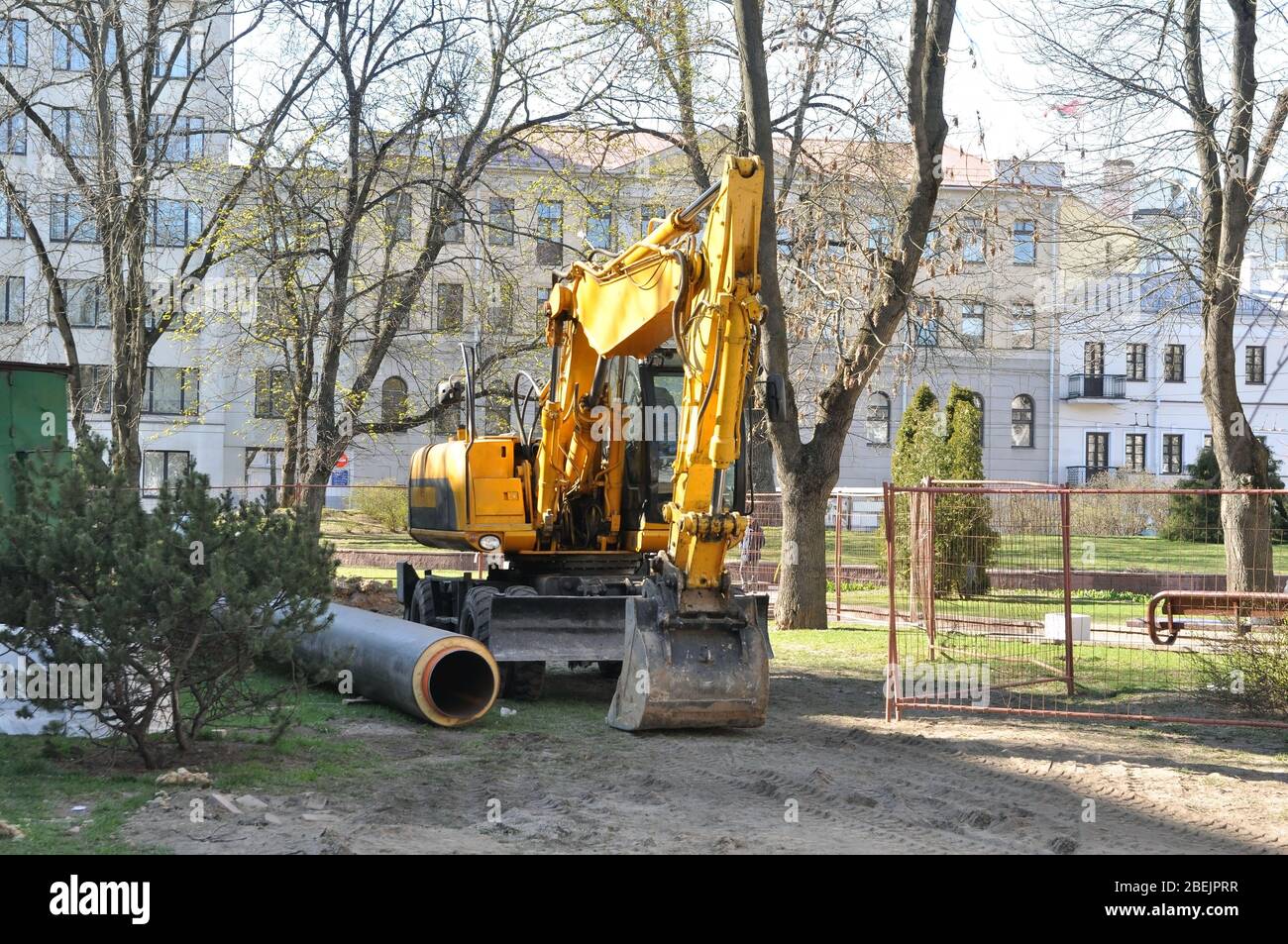 Lavori di riparazione in città per la conversione di reti di riscaldamento utilizzando l'escavatore. Foto Stock