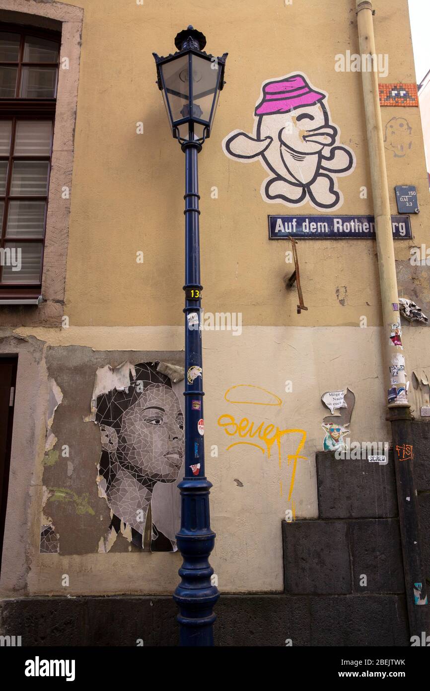 Poster e graffiti su un muro sulla corsia Auf dem Rothenberg nella parte vecchia della città, Colonia, Germania. Altes Plakat und Graffiti in der Gass Foto Stock