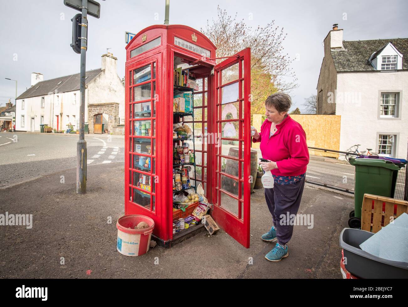 Susan Crawford controlla la comunità alimentare larder a Muthill, vicino Crieff nel Perthshire, che è stato istituito da residenti locali utilizzando la vecchia casella del villaggio come punto di raccolta e donazione di cibo, mentre il Regno Unito continua a bloccare per contribuire a frenare la diffusione del coronavirus. Foto Stock