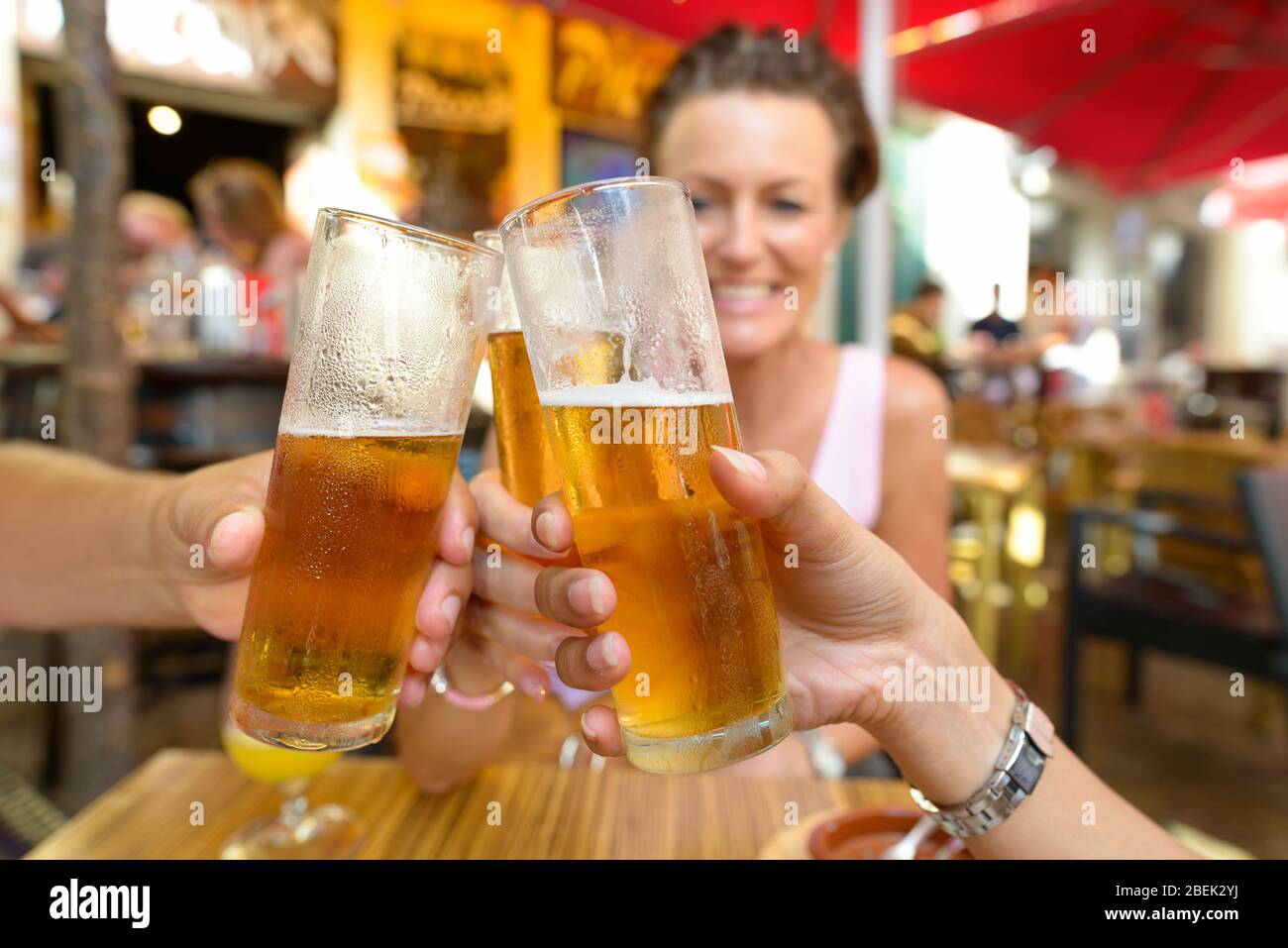 Happy Friends bere e tostare birra all'aperto al ristorante Foto Stock