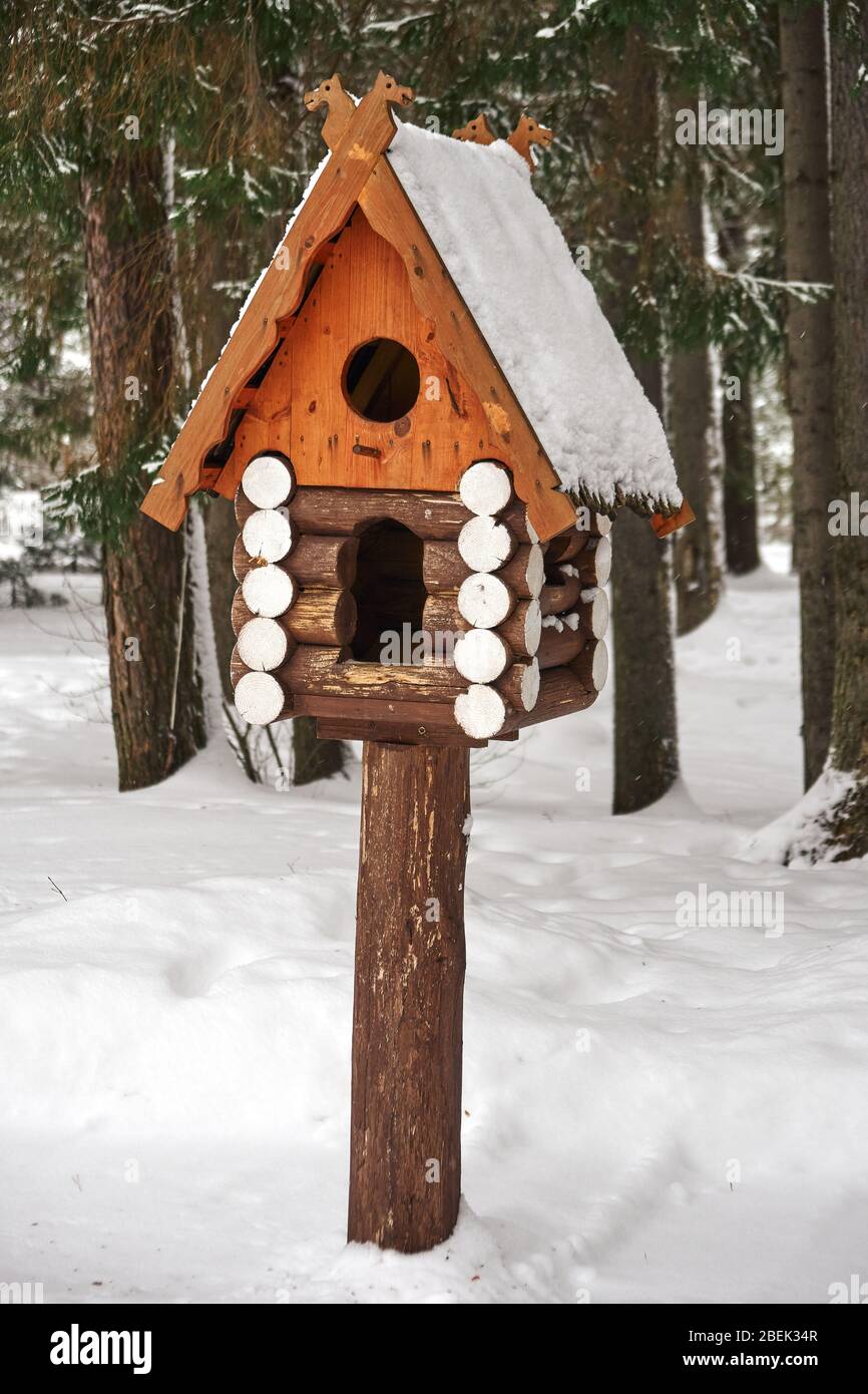 Birdhouse in legno. Casetta artigianale in legno di bosco innevato Foto Stock