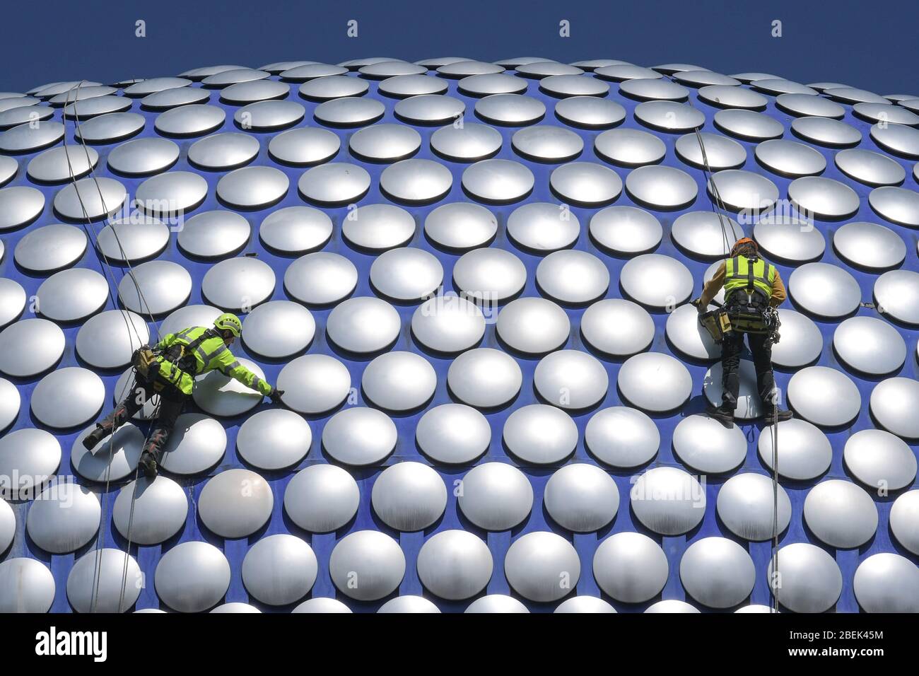 Birmingham, West Midlands, Regno Unito. 14 aprile 2020. Gli operai si scagliano lungo l'esterno del Selfridges nel centro di Birmingham per controllare se uno dei dischi è allentato. I lavoratori hanno utilizzato il blocco per lavorare senza causare gravi disagi ai pedoni sottostanti. Credito: Interrompi stampa Media/Alamy Live News Foto Stock