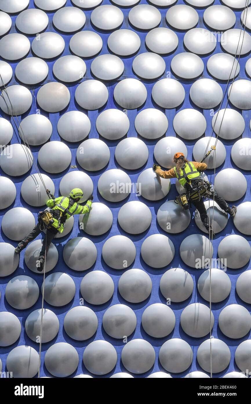 Birmingham, West Midlands, Regno Unito. 14 aprile 2020. Gli operai si scagliano lungo l'esterno del Selfridges nel centro di Birmingham per controllare se uno dei dischi è allentato. I lavoratori hanno utilizzato il blocco per lavorare senza causare gravi disagi ai pedoni sottostanti. Credito: Interrompi stampa Media/Alamy Live News Foto Stock
