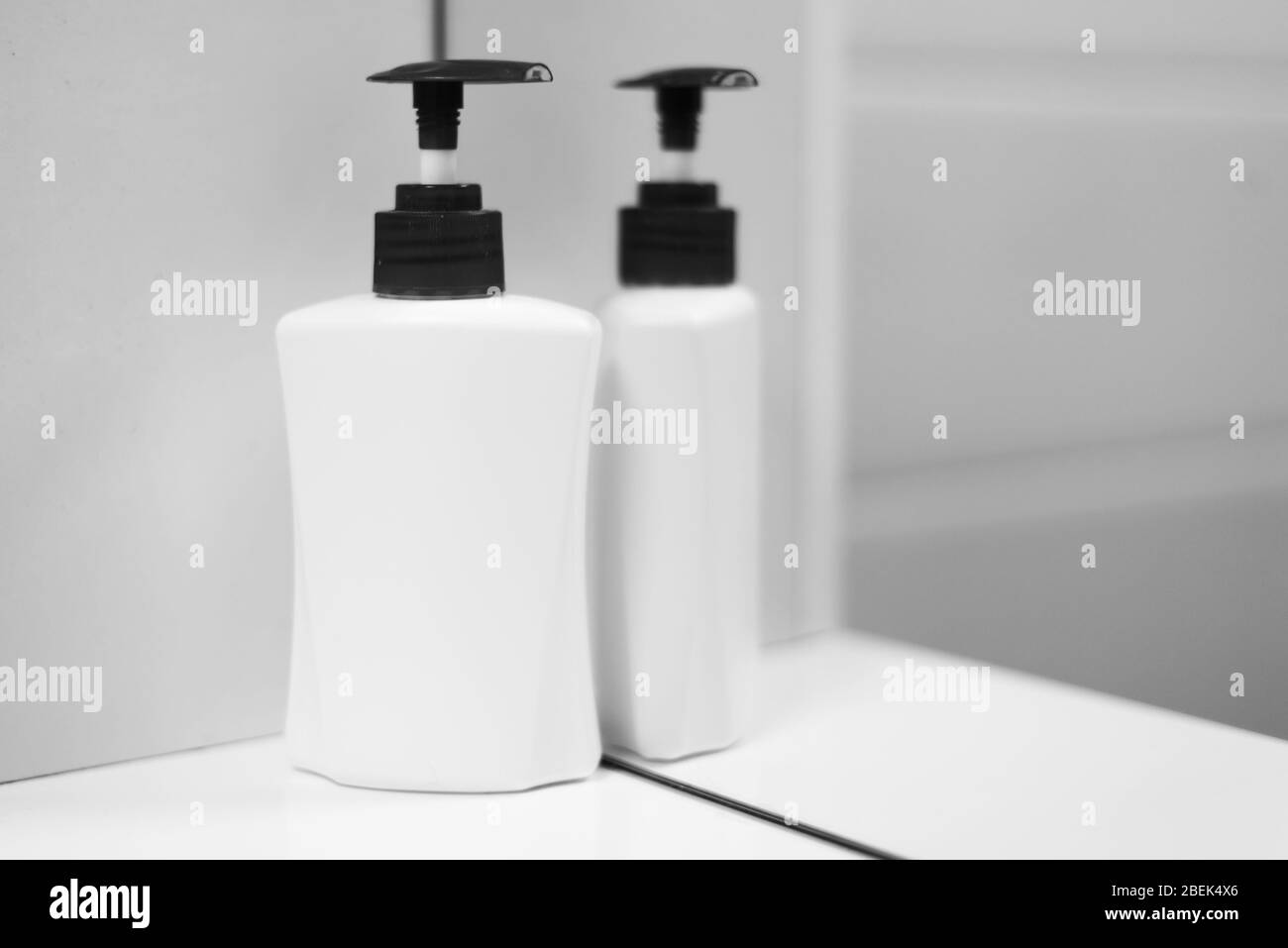 Una bottiglia di sapone bianco con riflessione a specchio. Foto ravvicinata. Foto Stock
