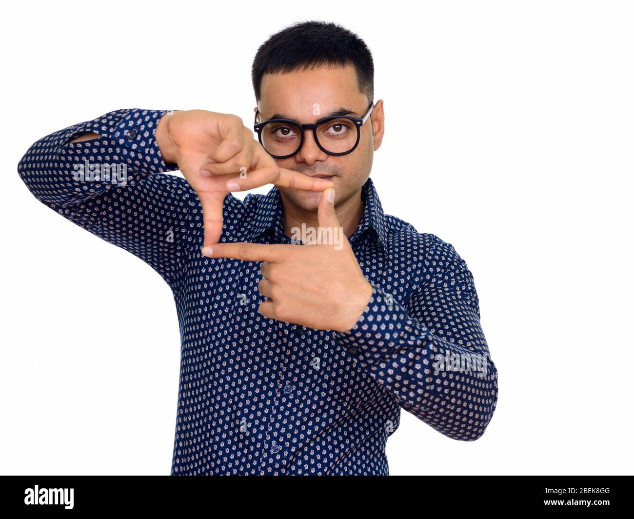 Studio di giovane bell'uomo indiano con occhiali focalizzati con dita isolate su sfondo bianco Foto Stock