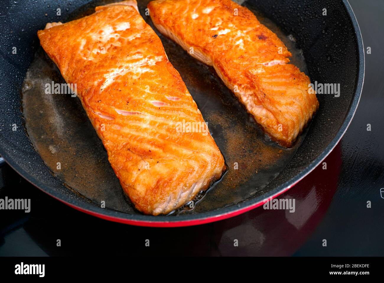 Filetti di salmone in padella da cucina su piano cottura a induzione. Primo  piano Foto stock - Alamy