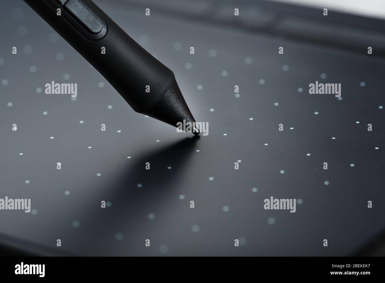 Primo piano penna e tavoletta grafica su sfondo grigio. Gadget per lavorare come designer, artista e fotografo. Foto Stock