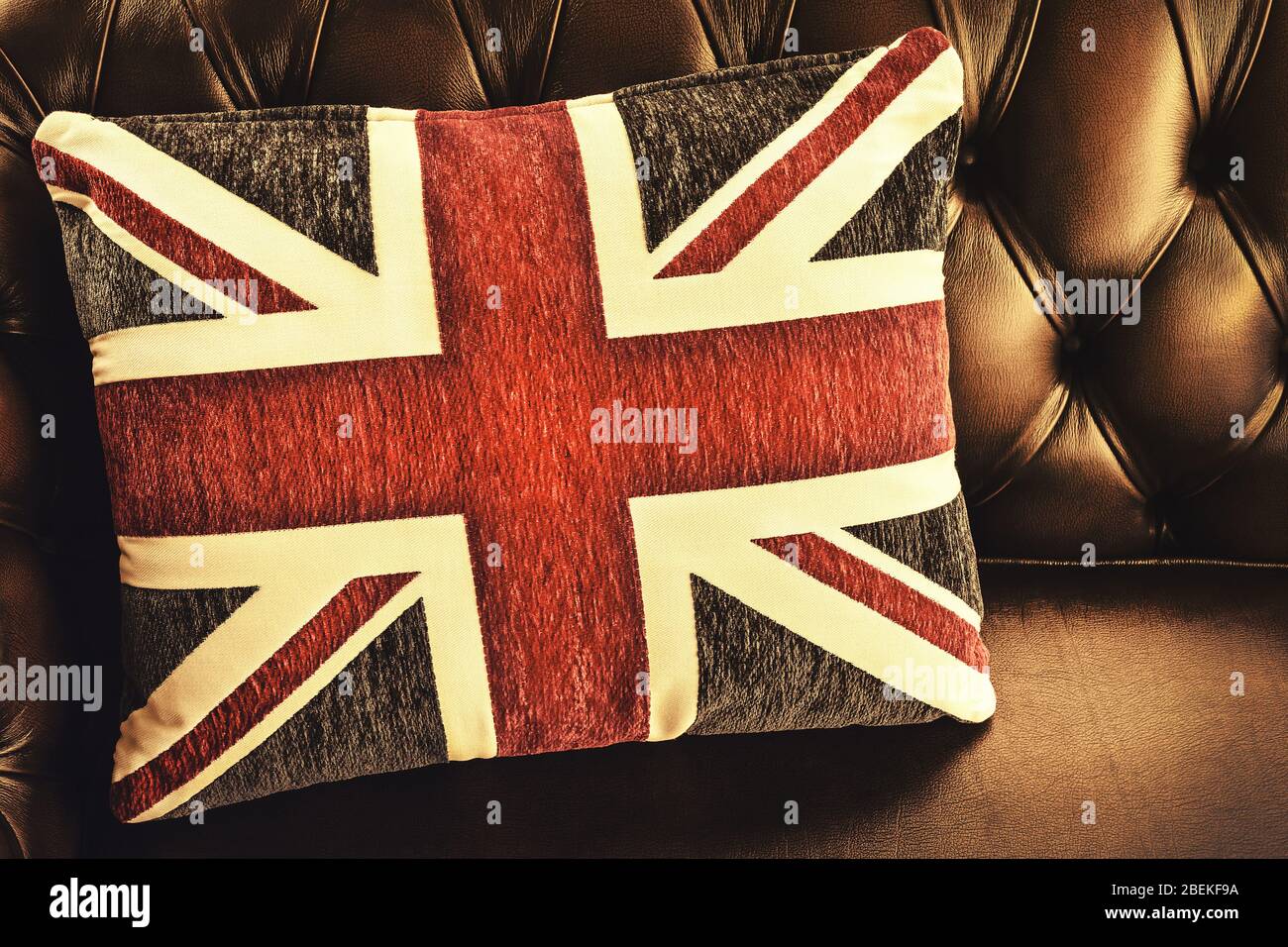 Immagine in stile retrò di un cuscino con bandiera inglese su un divano Chesterfield Foto Stock