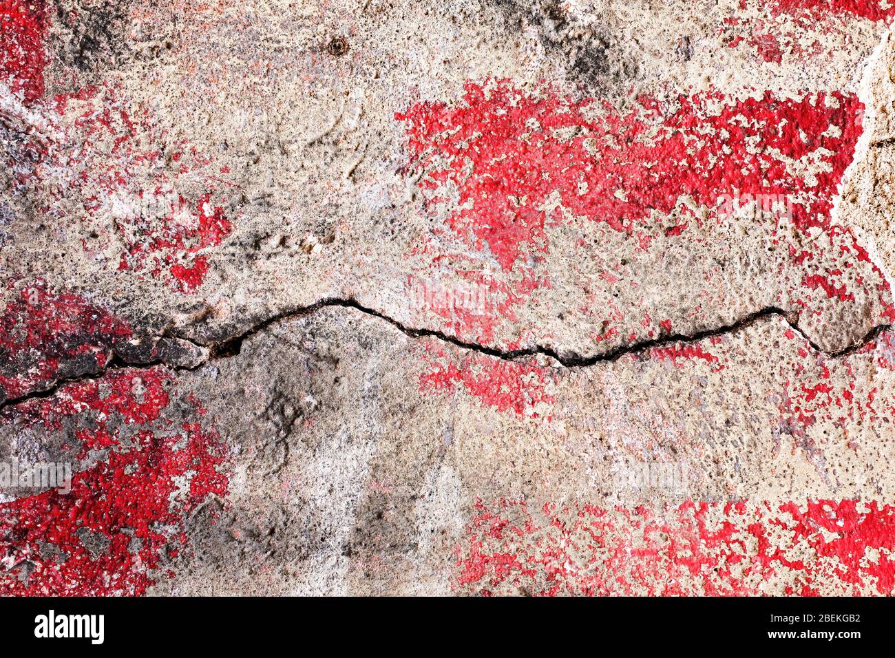 Vernice pelata superficie in intonaco da parete testurizzata con vernice rossa e nera. Grunge cracking parete texture sfondo. Foto Stock
