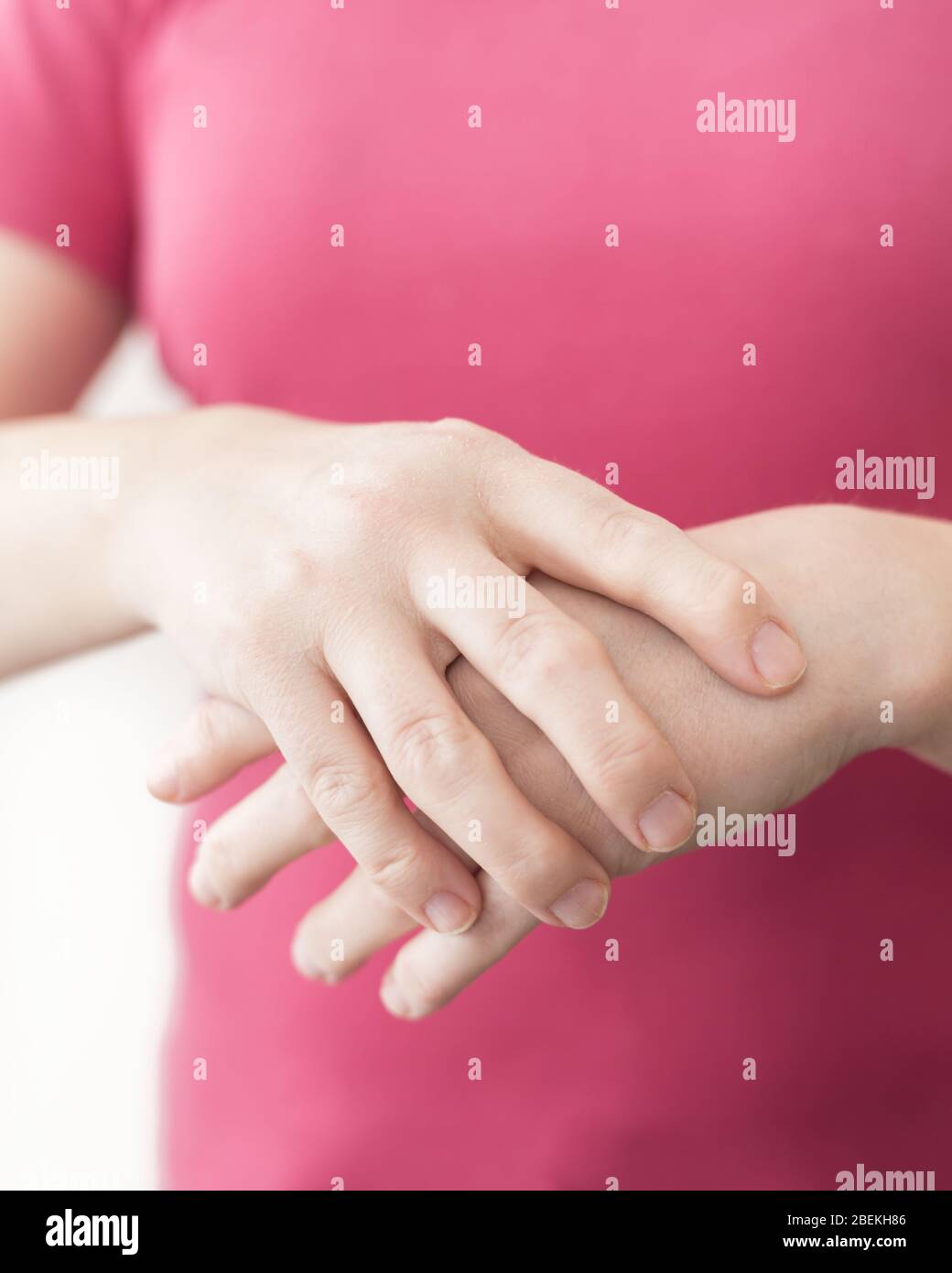 Primo piano giovane donna bianca che soffre di dolore ai polsi. Concetto di salute con mano reale di artrite reumatoide. Foto Stock