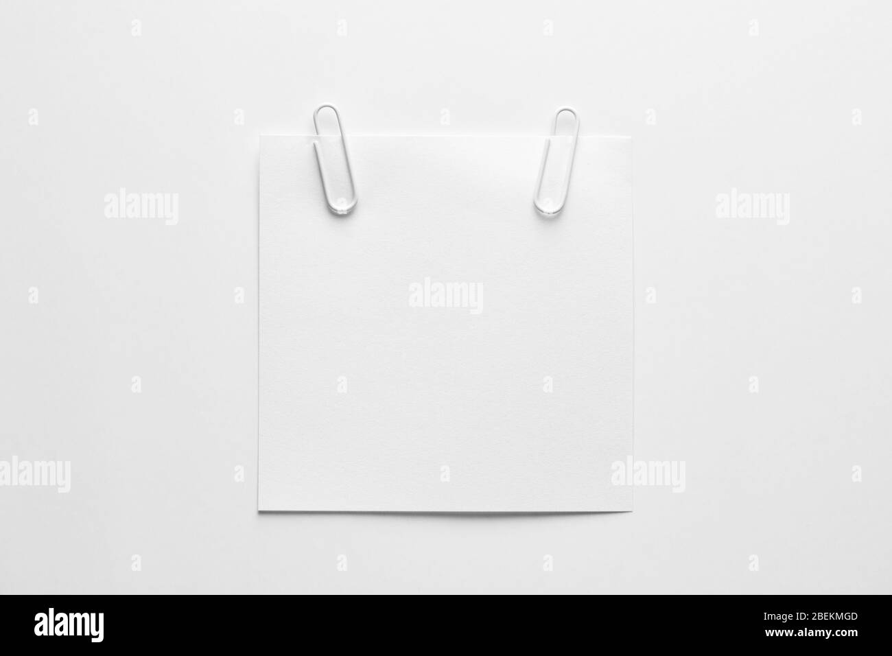 Carta per appunti bianca o blocco note con clip per carta bianca su sfondo bianco con spazio per le copie. Testo del promemoria Foto Stock