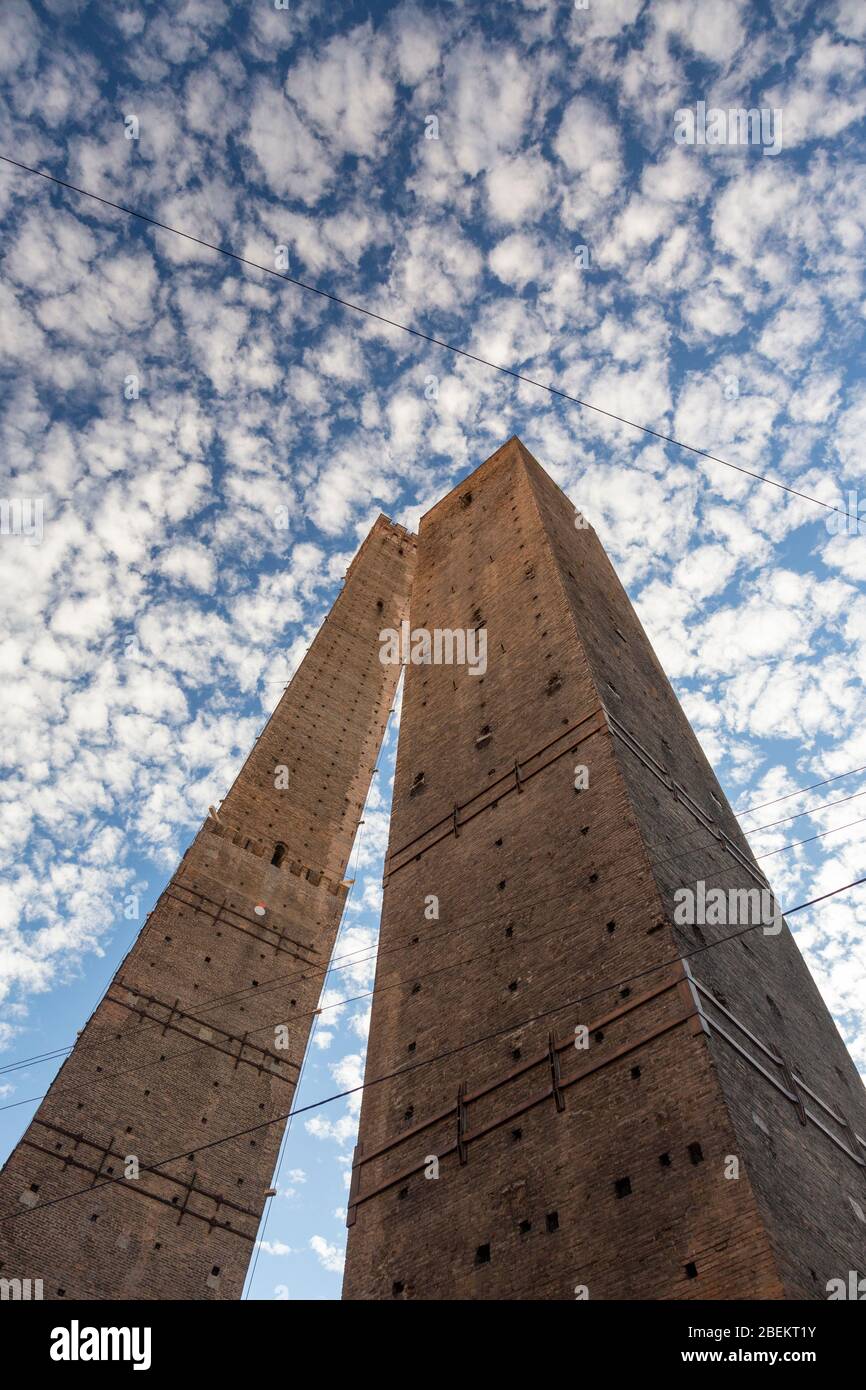 Vista a basso angolo delle due Torri (le due torri) con le nuvole Cirrocumulus nel cielo, Bologna, Italia Foto Stock