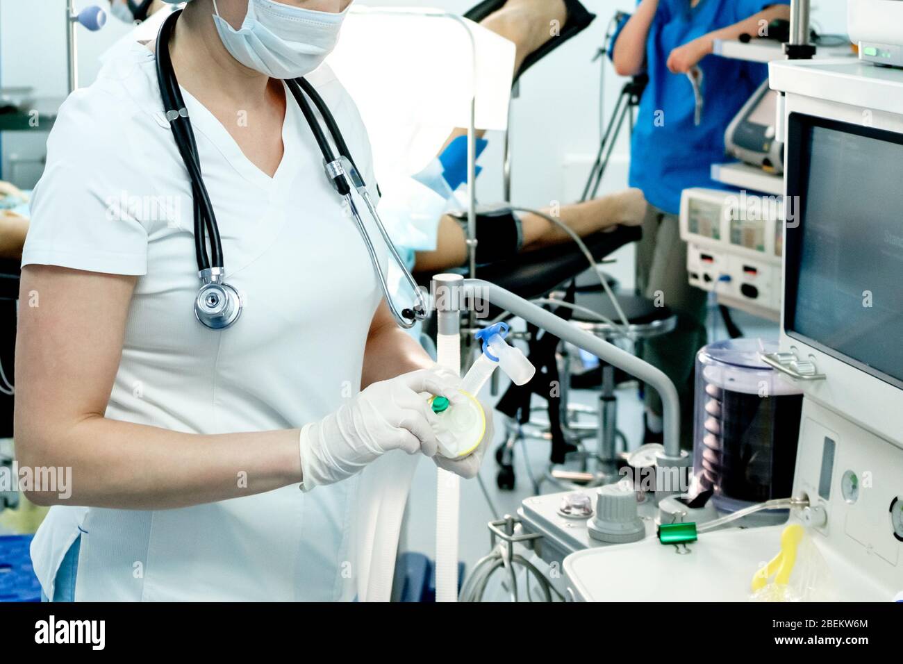 Un medico di terapia intensiva prepara attrezzature per la ventilazione artificiale dei polmoni per l'intubazione in un paziente critico con coronavirus. COVID-19 Foto Stock